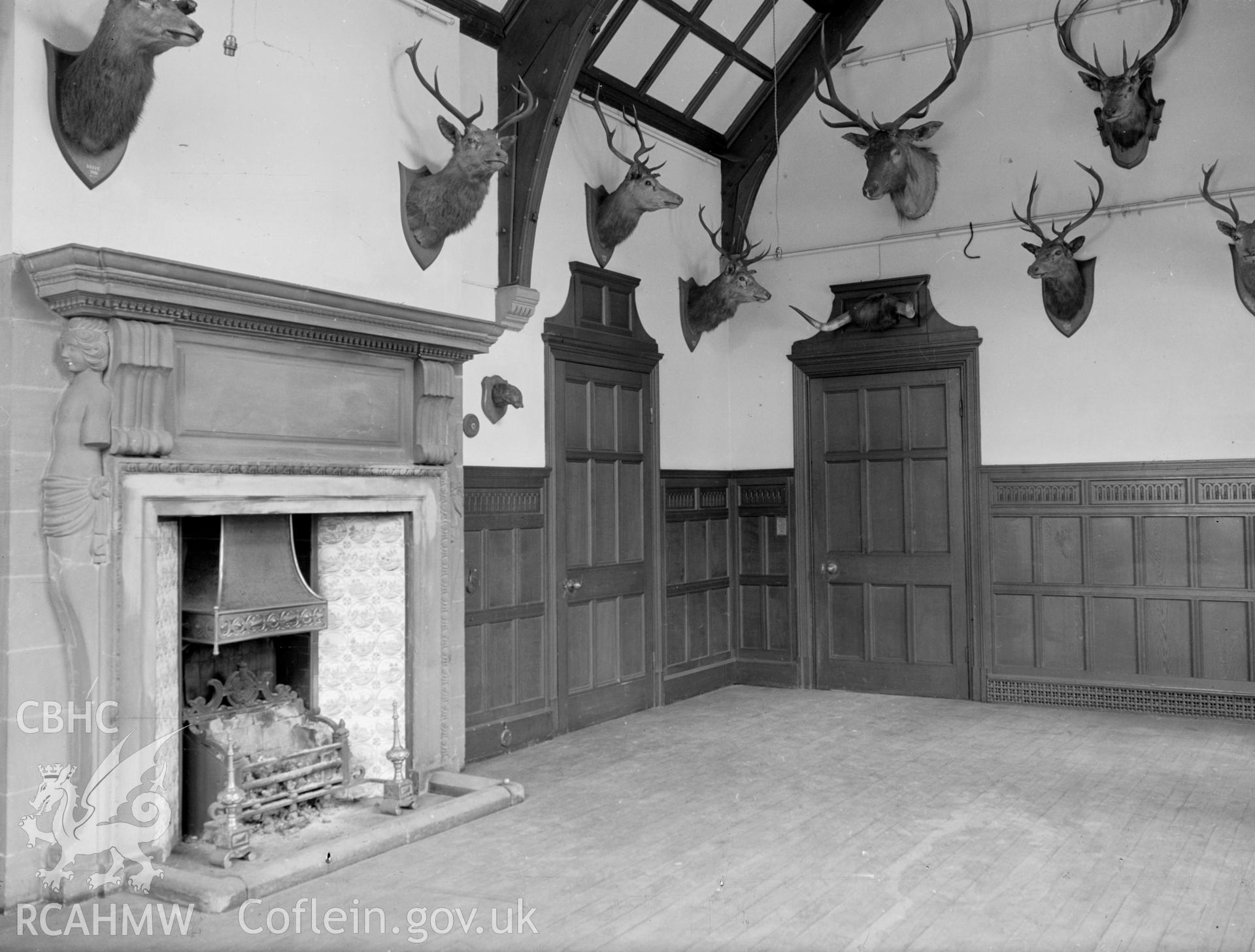 A view of the south eastern tower entrance: A wooden floor room with a large carved stone fireplace.