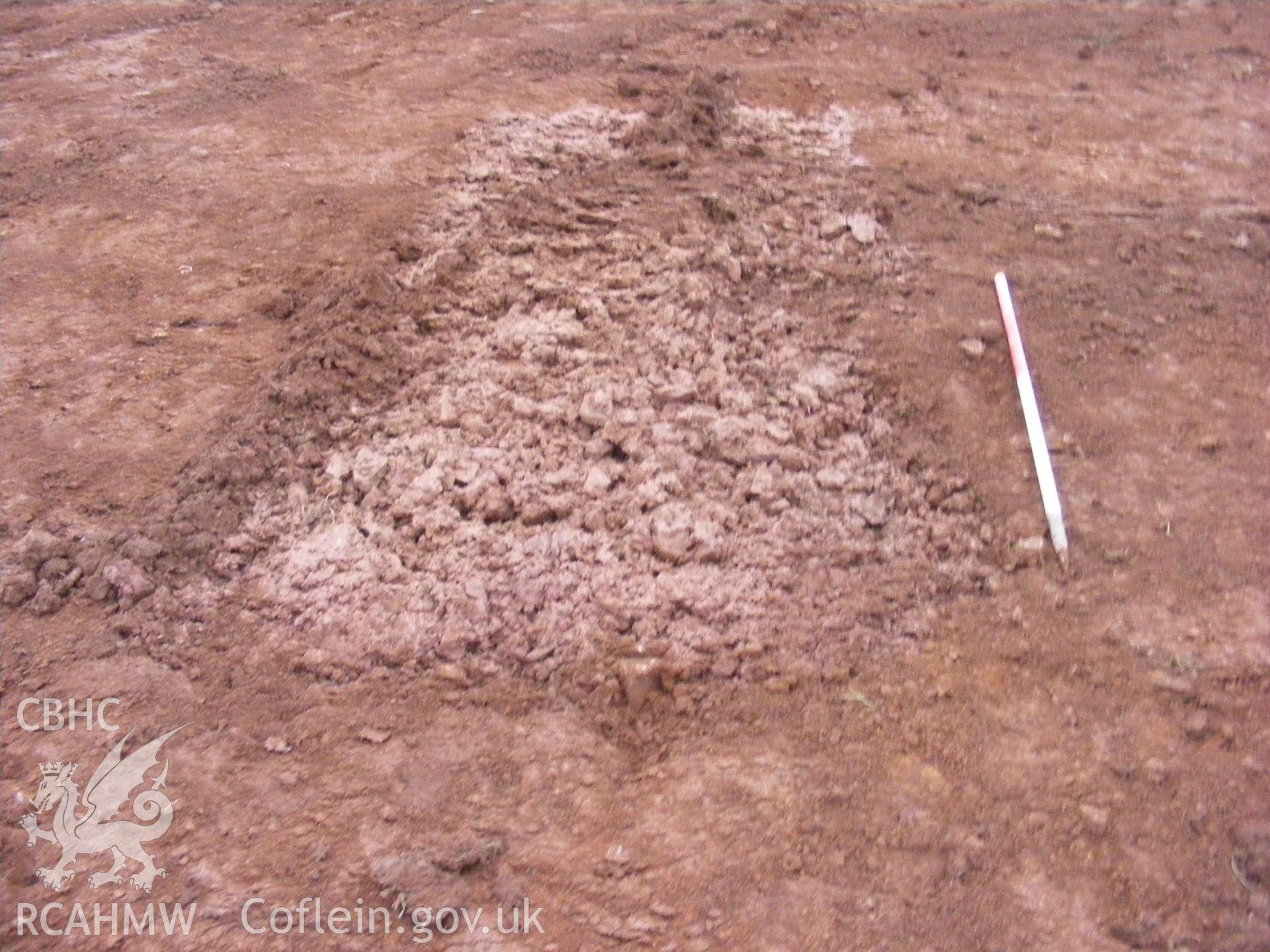 View showing test pit facing west, taken at archaeological watching brief at Princes Gate Spring Water, produced by Headland Archaeology (UK) Ltd., 2014.
