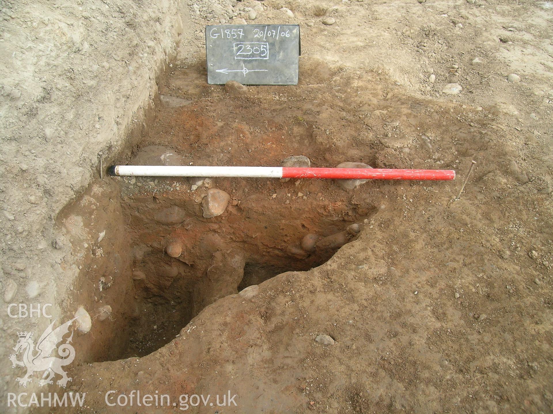 Digital photograph from excavation of Parc Bryn Cegin, Llandygai, by Gwynedd Archaeological Trust. 2305 sectioned, from E (numbers refer to context records). Scale 1 x 1m.