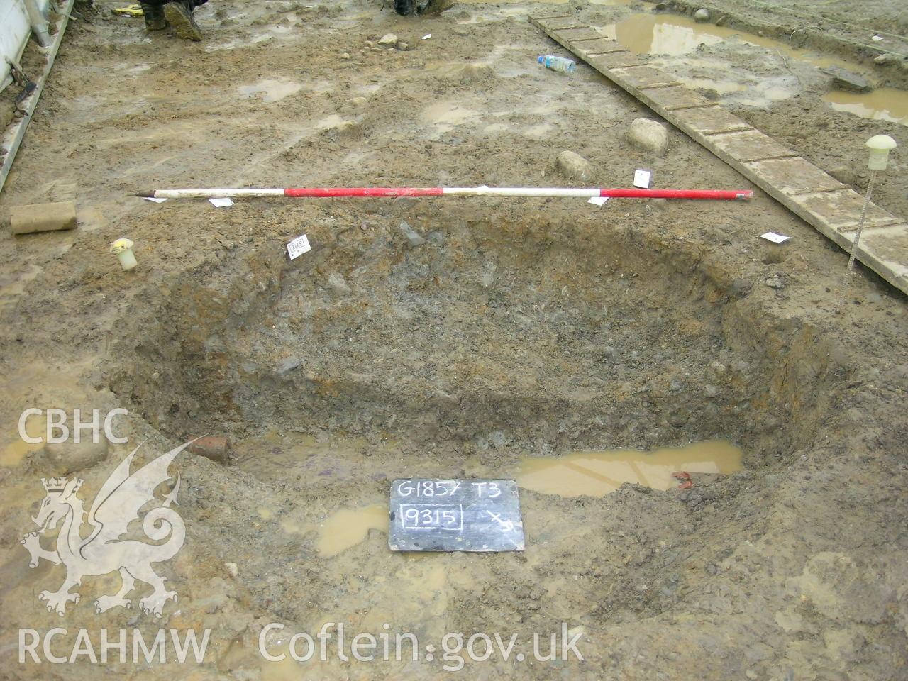 Digital photograph from excavation of Parc Bryn Cegin, Llandygai, by Gwynedd Archaeological Trust. Post-ex. Of pit [9315], from NE (numbers refer to context records). Scale 1x2m.