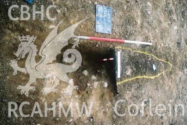 Photograph from excavation of Parc Bryn Cegin, Llandygai, by Gwynedd Archaeological Trust. Section through [3026], from NW (numbers refer to context records). Scale 1x1m, 1x0.2m, 1x0.3m.