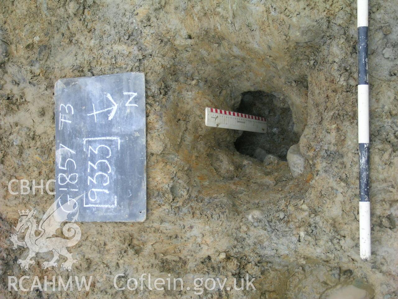 Digital photograph from excavation of Parc Bryn Cegin, Llandygai, by Gwynedd Archaeological Trust. Post-ex. Of [9333] posthole, from S (numbers refer to context records). Scale 1x0.5m, 1x0.3m.