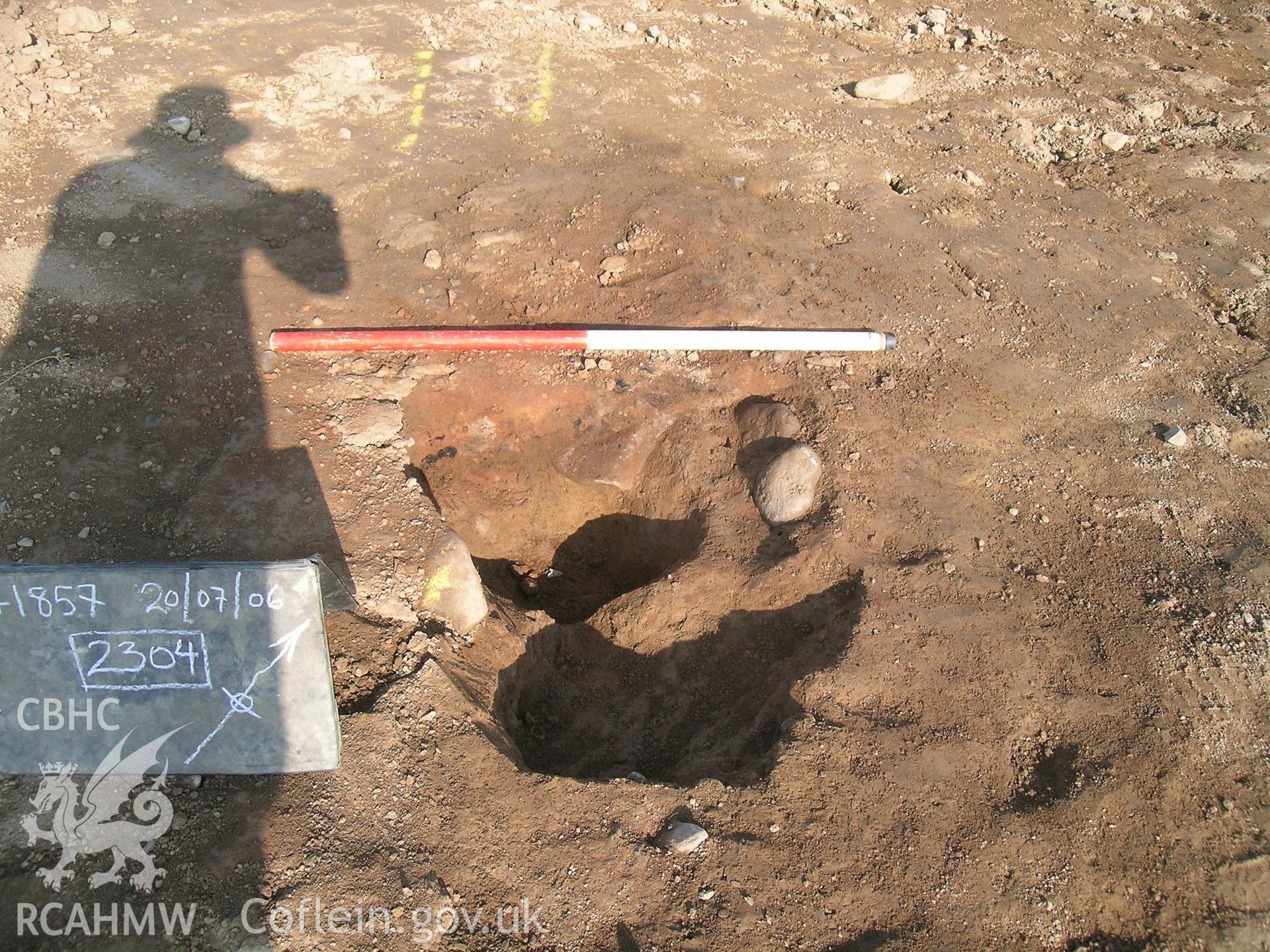 Digital photograph from excavation of Parc Bryn Cegin, Llandygai, by Gwynedd Archaeological Trust. 2304 sectioned, from SE (numbers refer to context records). Scale 1 x 1m.