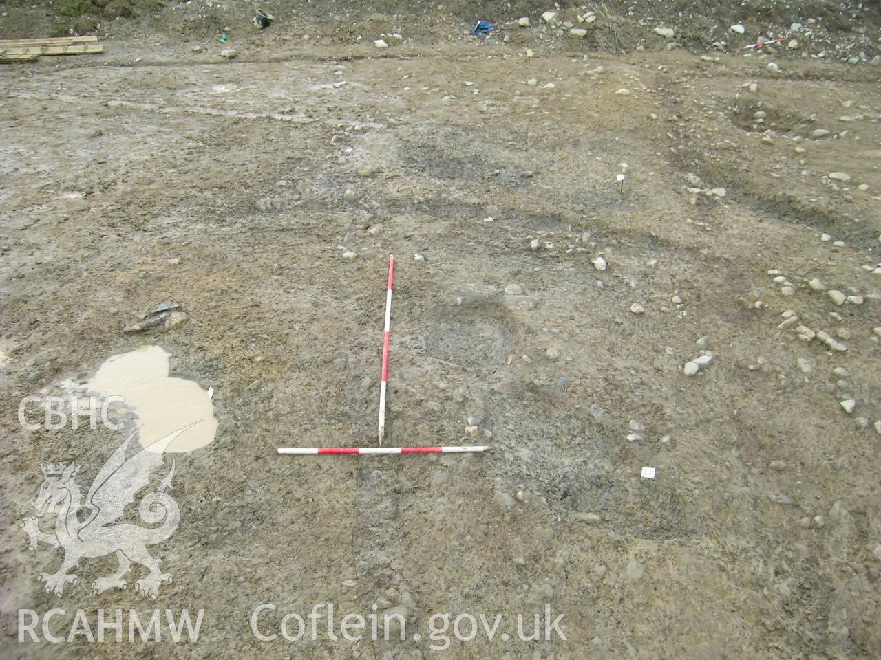 Digital photograph from excavation of Parc Bryn Cegin, Llandygai, by Gwynedd Archaeological Trust. P-ex. [9320], [9318] & [9316], from W (numbers refer to context records). Scale 1x2m.