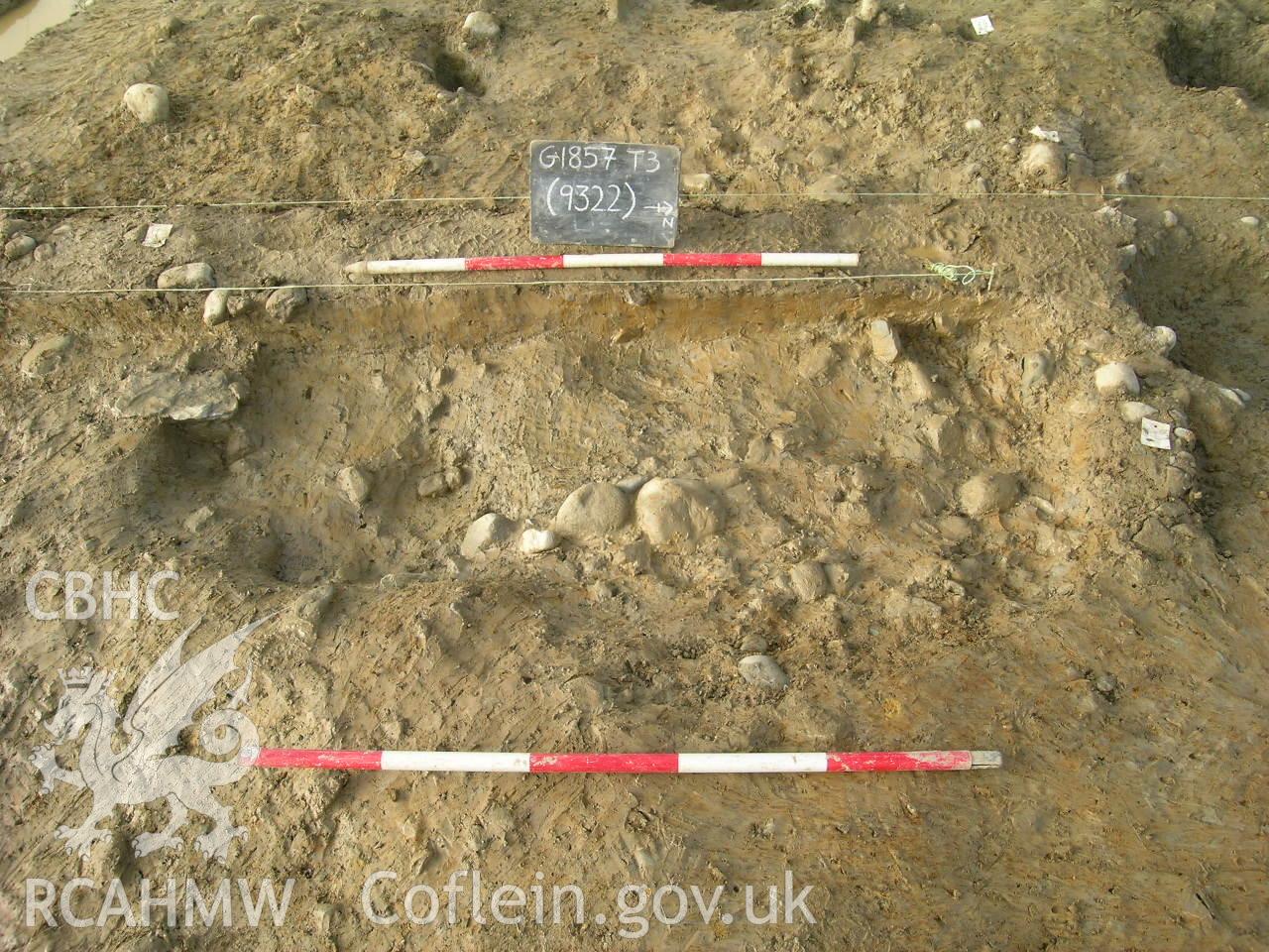 Digital photograph from excavation of Parc Bryn Cegin, Llandygai, by Gwynedd Archaeological Trust. Post-ex. Of [9322], from E (numbers refer to context records). Scale 1x1m.