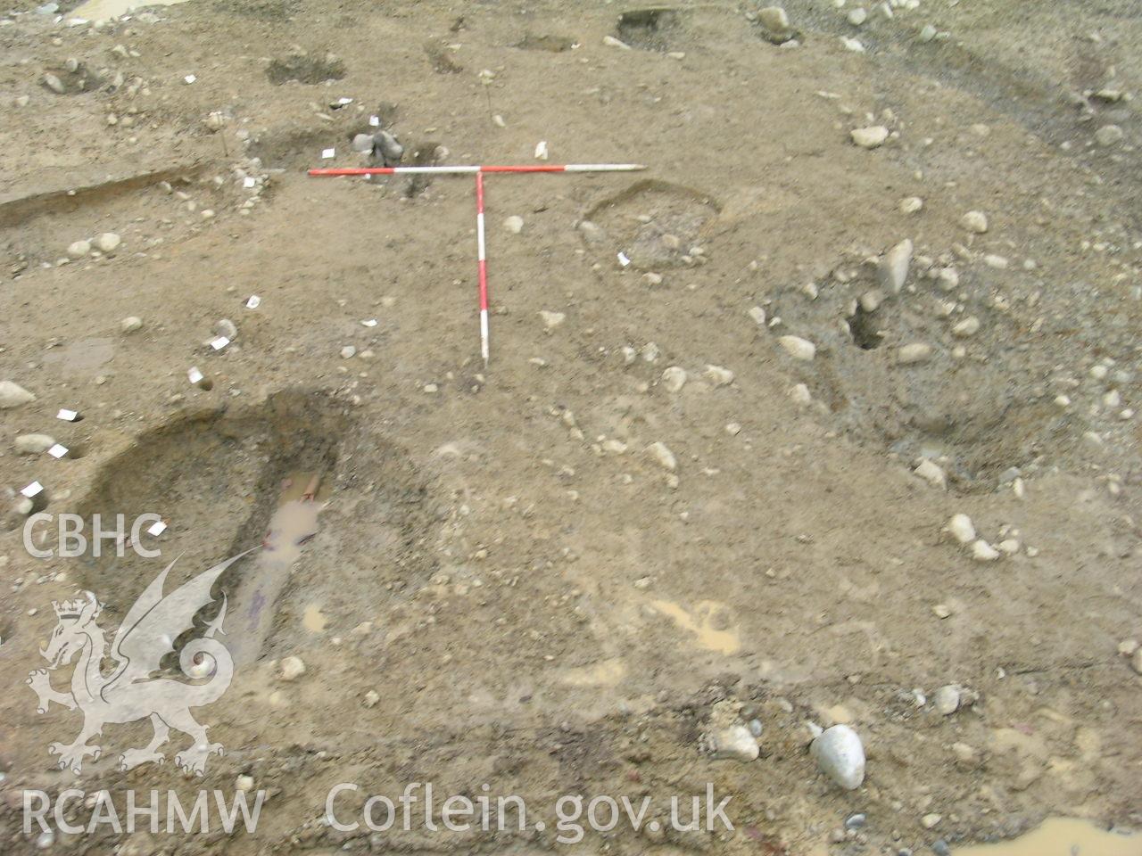 Digital photograph from excavation of Parc Bryn Cegin, Llandygai, by Gwynedd Archaeological Trust. Pits [9315] & [9307], from E (numbers refer to context records). Scale 2x2m.