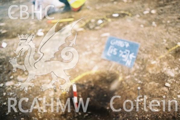 Photograph from excavation of Parc Bryn Cegin, Llandygai, by Gwynedd Archaeological Trust. Post holes [1573] & [1581], from W (numbers refer to context records). Scale 1x0.3m, 1x0.2m.