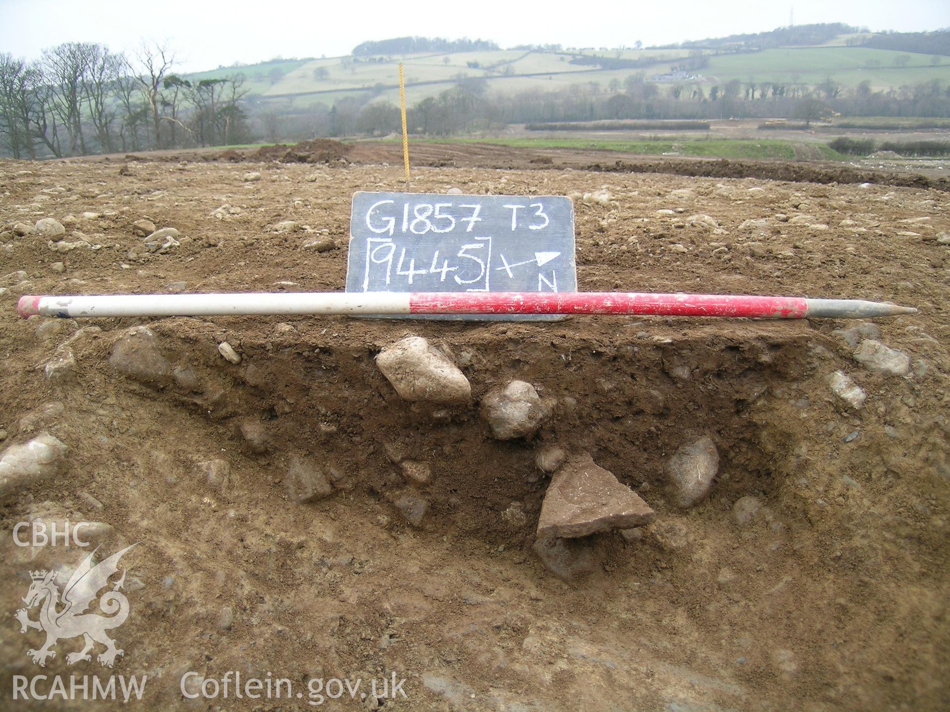 Digital photograph from excavation of Parc Bryn Cegin, Llandygai, by Gwynedd Archaeological Trust. section through pit 9445, from E (numbers refer to context records). Scale 1 x 1m.