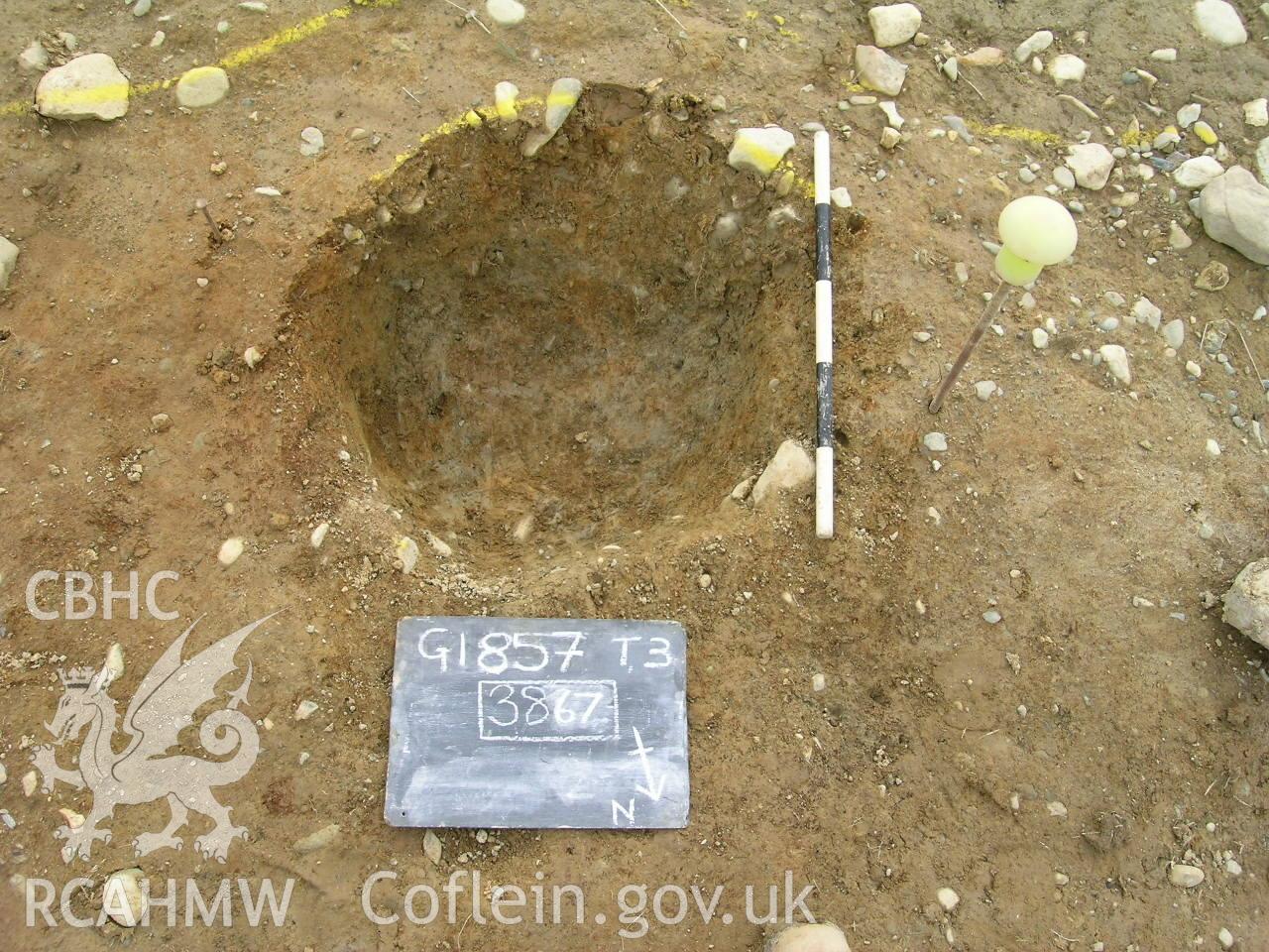 Digital photograph from excavation of Parc Bryn Cegin, Llandygai, by Gwynedd Archaeological Trust. Post-exc. Pit [3867], from NE (numbers refer to context records). Scale 0.5m.