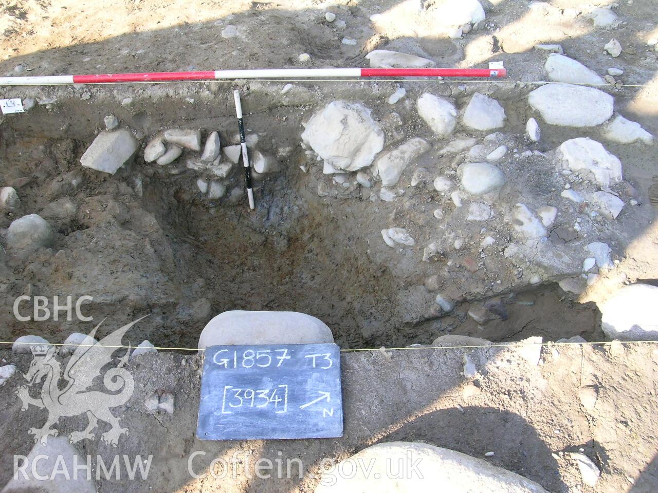 Digital photograph from excavation of Parc Bryn Cegin, Llandygai, by Gwynedd Archaeological Trust. Section through ditch [3934], from SE (numbers refer to context records). Scale 1x2m, 1x0.5m.