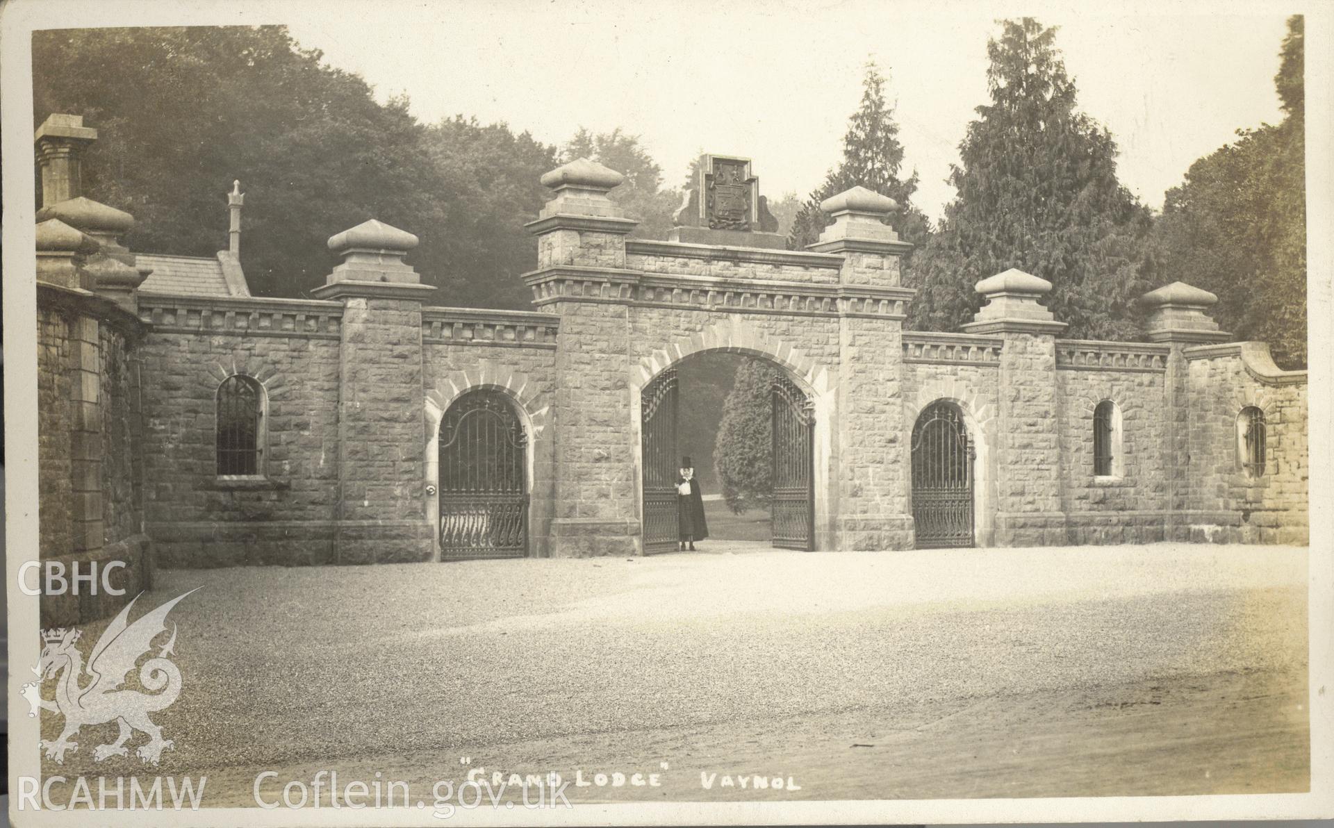 Digitised postcard image of Main Entrance and Lodge, Vaynol, with figure in Welsh costume, J.H. Jones, Port Dinorwic. Produced by Parks and Gardens Data Services, from an original item in the Peter Davis Collection at Parks and Gardens UK. We hold only web-resolution images of this collection, suitable for viewing on screen and for research purposes only. We do not hold the original images, or publication quality scans.