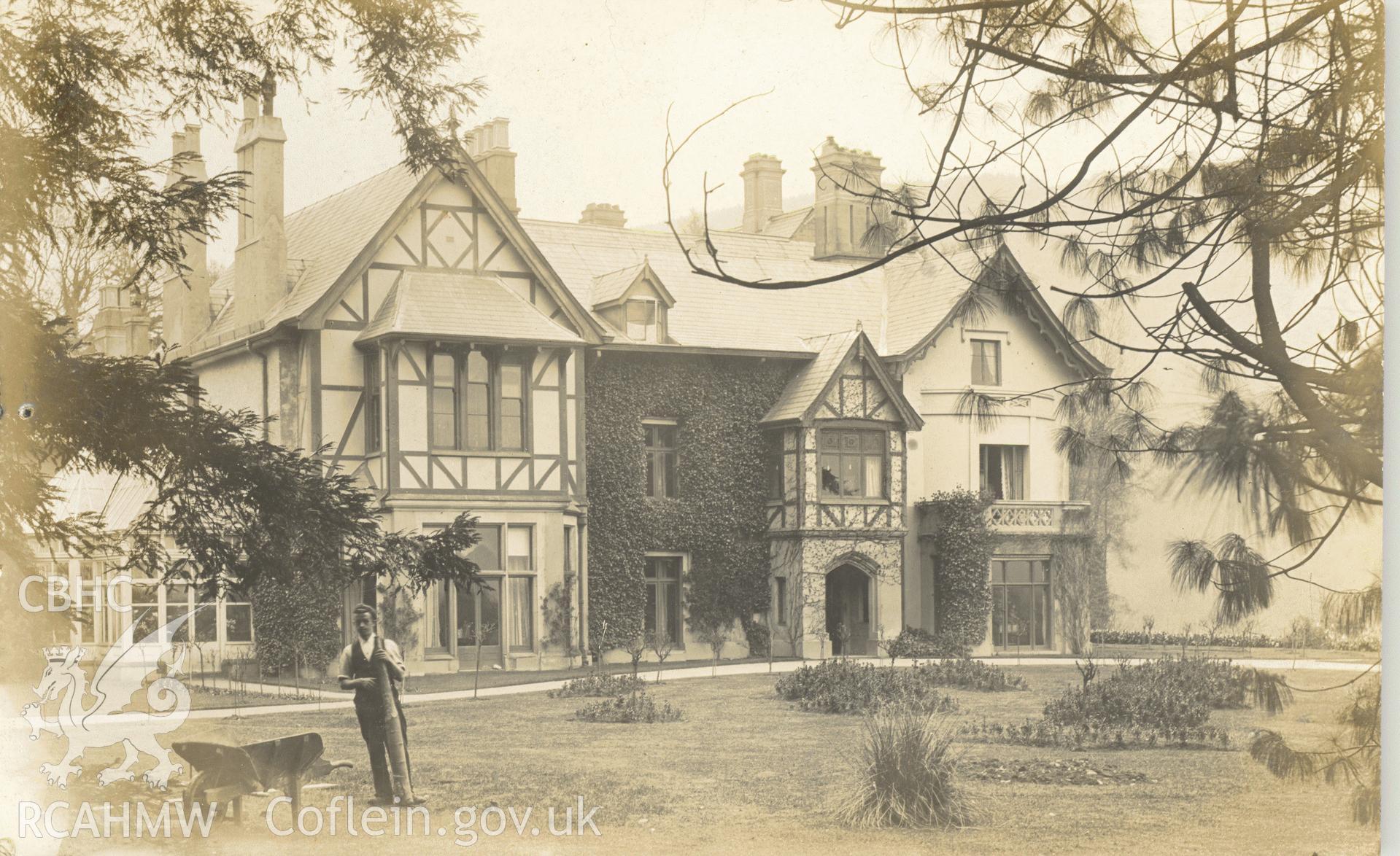 Digitised postcard image of Ty-Mawr, Gilwern, with gardener. Produced by Parks and Gardens Data Services, from an original item in the Peter Davis Collection at Parks and Gardens UK. We hold only web-resolution images of this collection, suitable for viewing on screen and for research purposes only. We do not hold the original images, or publication quality scans.