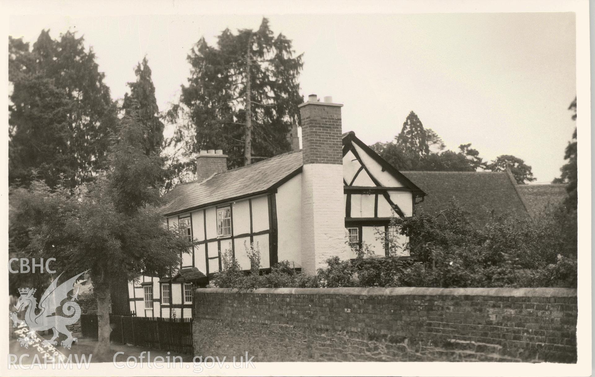 Digitised postcard image of unidentified timebered house, pollared ash trees and wall, W.J. Yates and Sons, Kington. Produced by Parks and Gardens Data Services, from an original item in the Peter Davis Collection at Parks and Gardens UK. We hold only web-resolution images of this collection, suitable for viewing on screen and for research purposes only. We do not hold the original images, or publication quality scans.