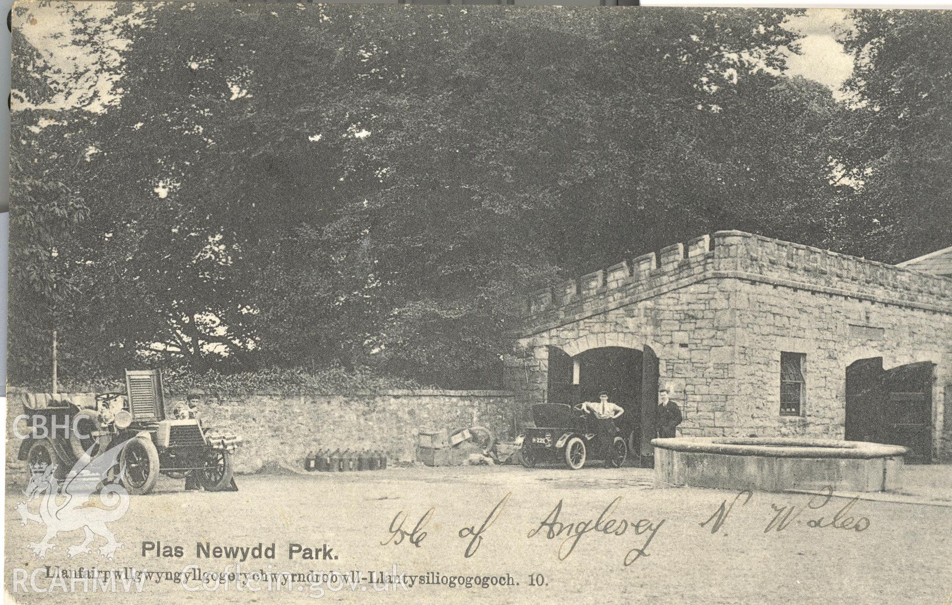 Digitised postcard image of Plas Newydd grounds, Llanddaniel Fab, including garages, E.E. Roberts' Series  LlanfairPG. Produced by Parks and Gardens Data Services, from an original item in the Peter Davis Collection at Parks and Gardens UK. We hold only web-resolution images of this collection, suitable for viewing on screen and for research purposes only. We do not hold the original images, or publication quality scans.