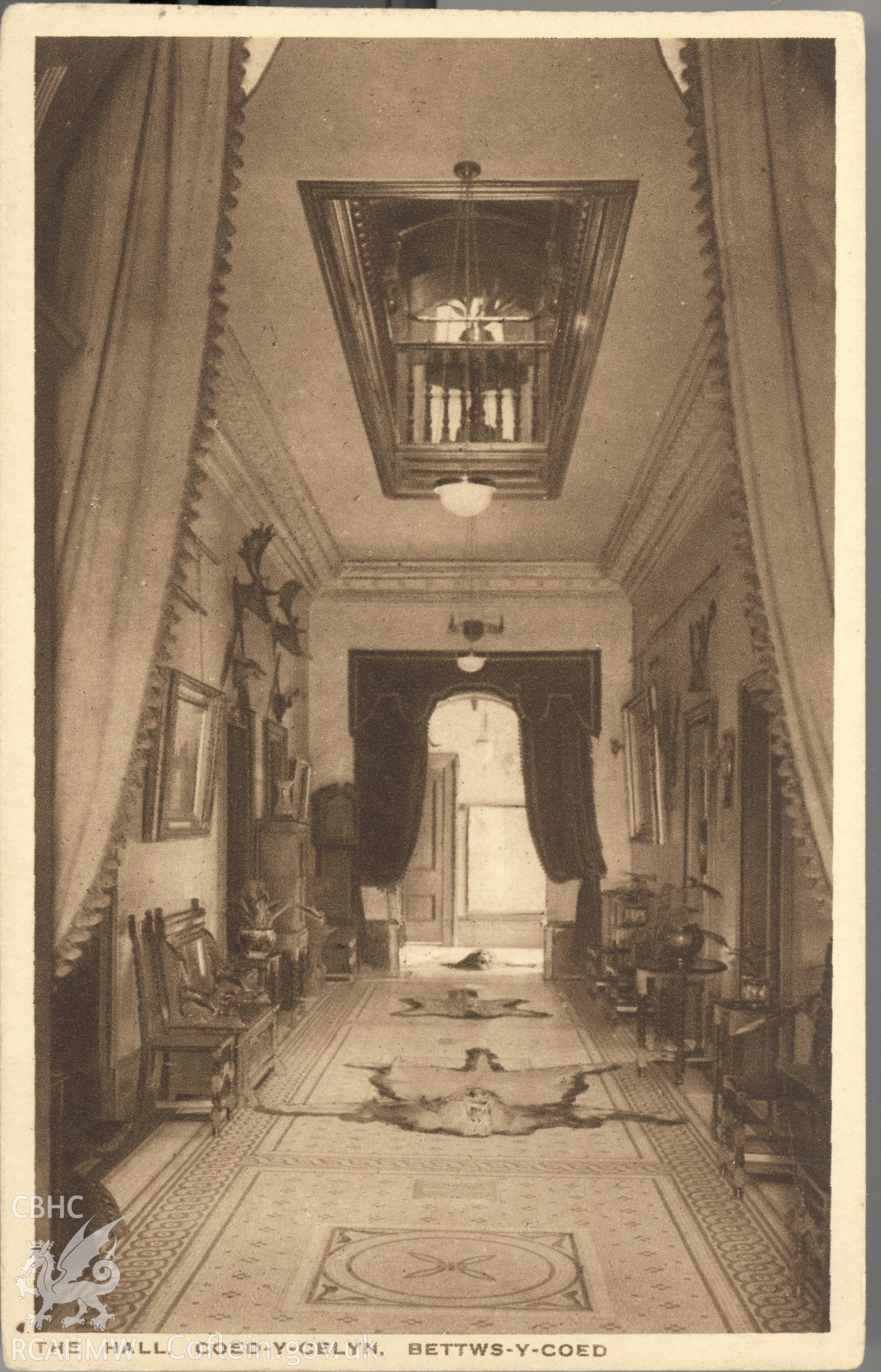 Digitised postcard image of interior of hall at Coed-y-Celyn, Betws-y-Coed, the R.A.P. Co. Ltd. Produced by Parks and Gardens Data Services, from an original item in the Peter Davis Collection at Parks and Gardens UK. We hold only web-resolution images of this collection, suitable for viewing on screen and for research purposes only. We do not hold the original images, or publication quality scans.