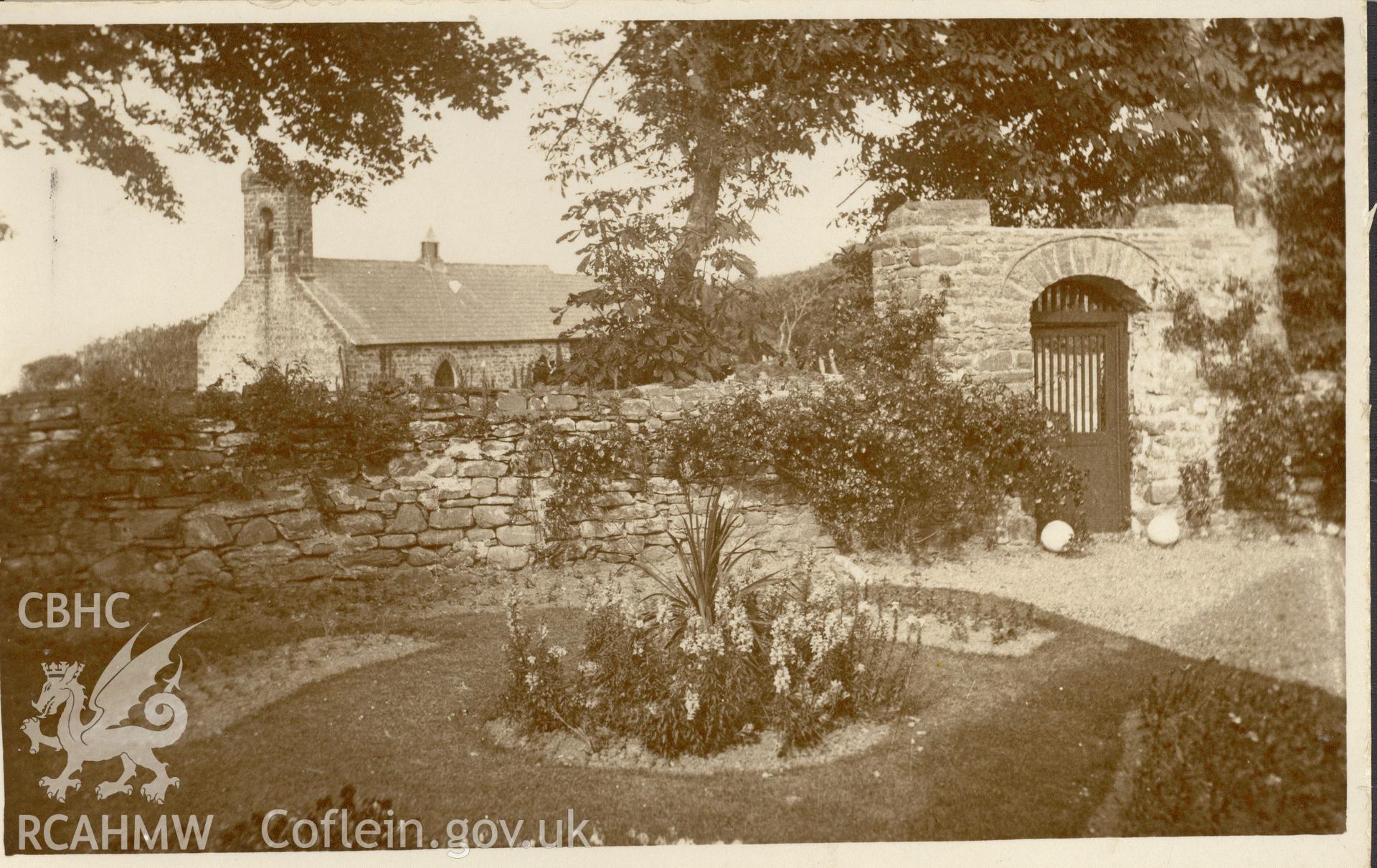 Digitised postcard image of garden near St Ina's church and lychgate, Llanina. Produced by Parks and Gardens Data Services, from an original item in the Peter Davis Collection at Parks and Gardens UK. We hold only web-resolution images of this collection, suitable for viewing on screen and for research purposes only. We do not hold the original images, or publication quality scans.
