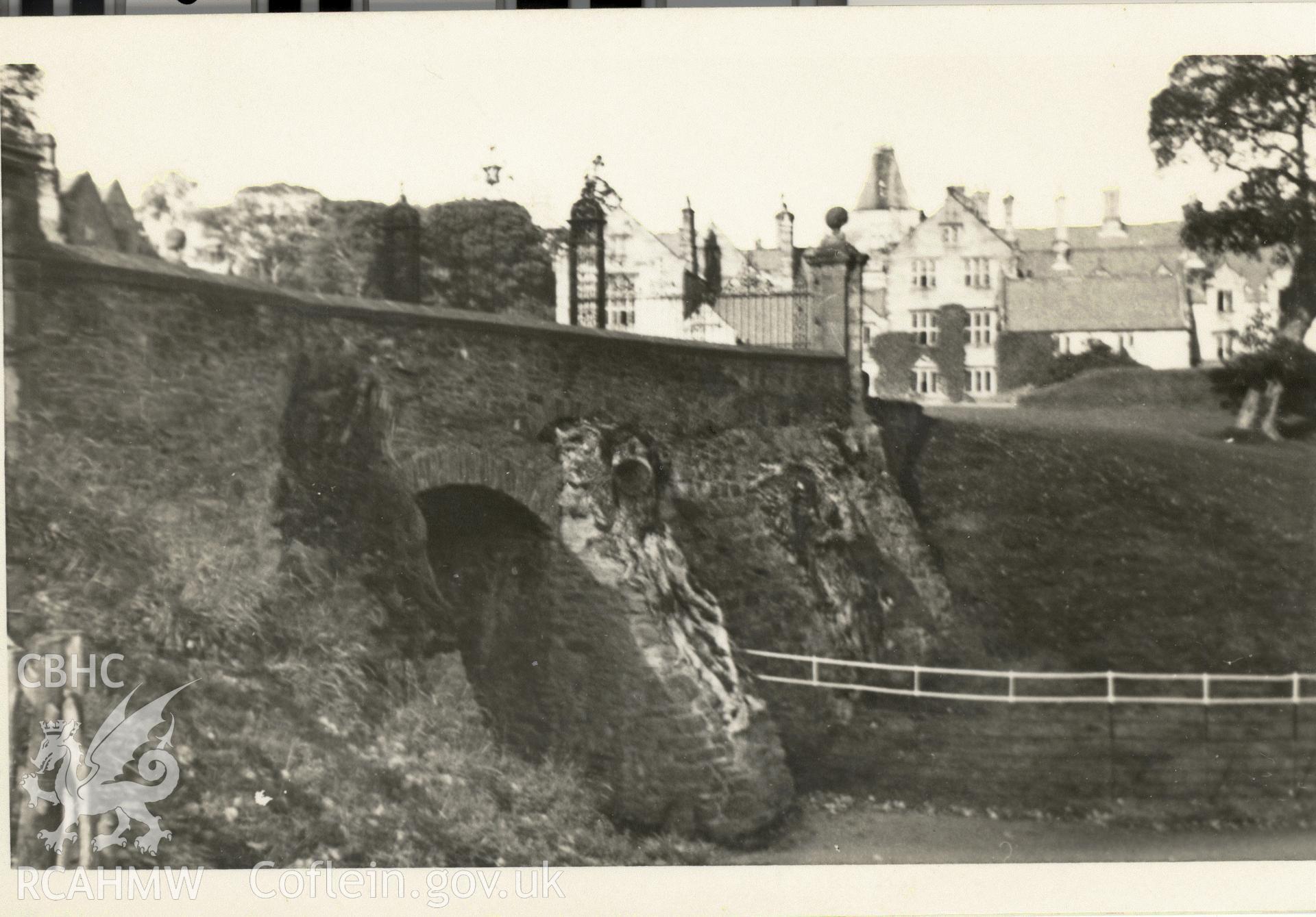 Digitised postcard image of bridge and gates on drive to Mostyn Hall, F.A. Gay, Photographer, Tenby. Produced by Parks and Gardens Data Services, from an original item in the Peter Davis Collection at Parks and Gardens UK. We hold only web-resolution images of this collection, suitable for viewing on screen and for research purposes only. We do not hold the original images, or publication quality scans.