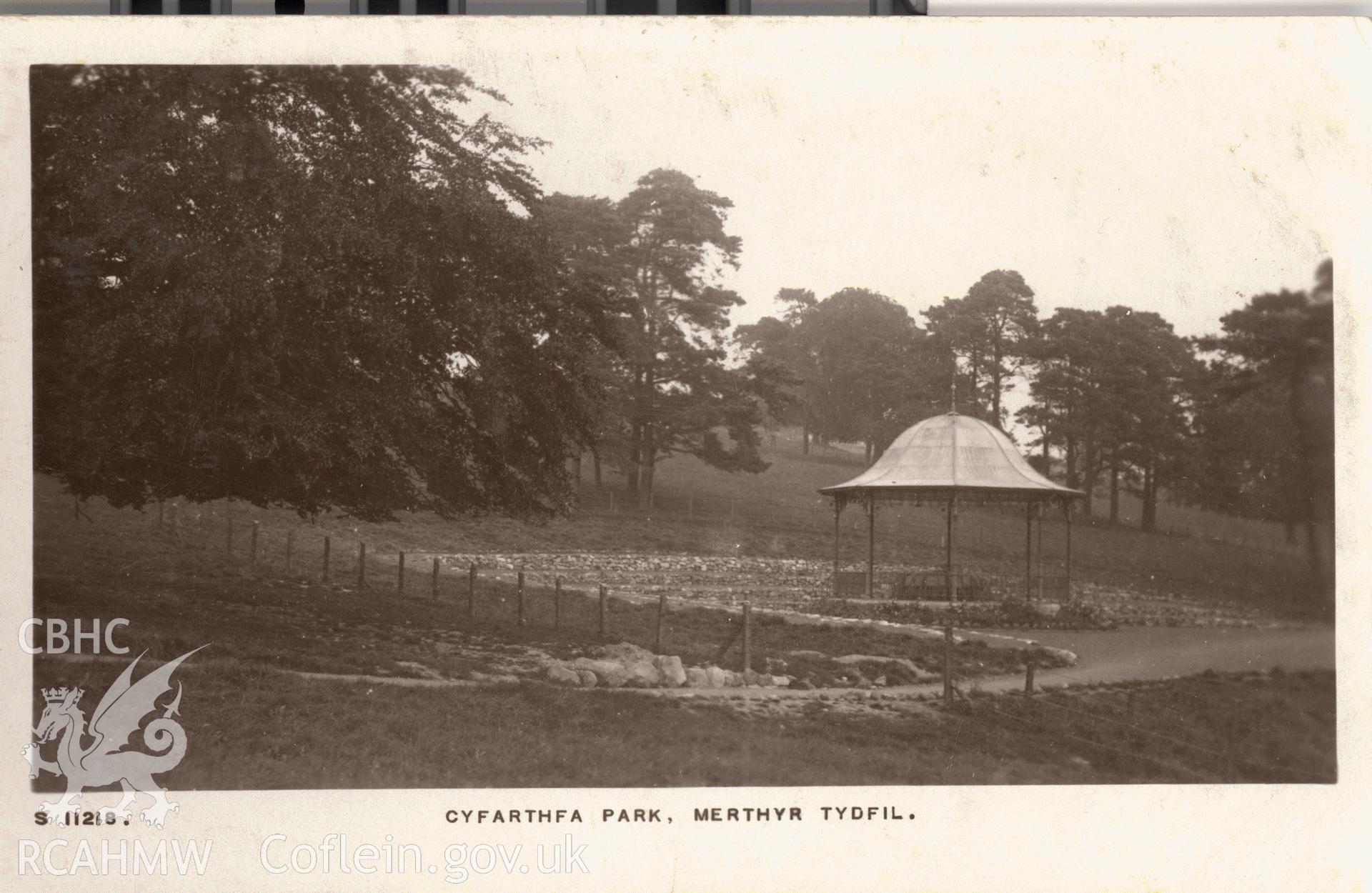Digitised postcard image of Cyfarthfa Park, Merthyr Tydfil, showing bandstand, Kingsway real Photo Series. Produced by Parks and Gardens Data Services, from an original item in the Peter Davis Collection at Parks and Gardens UK. We hold only web-resolution images of this collection, suitable for viewing on screen and for research purposes only. We do not hold the original images, or publication quality scans.