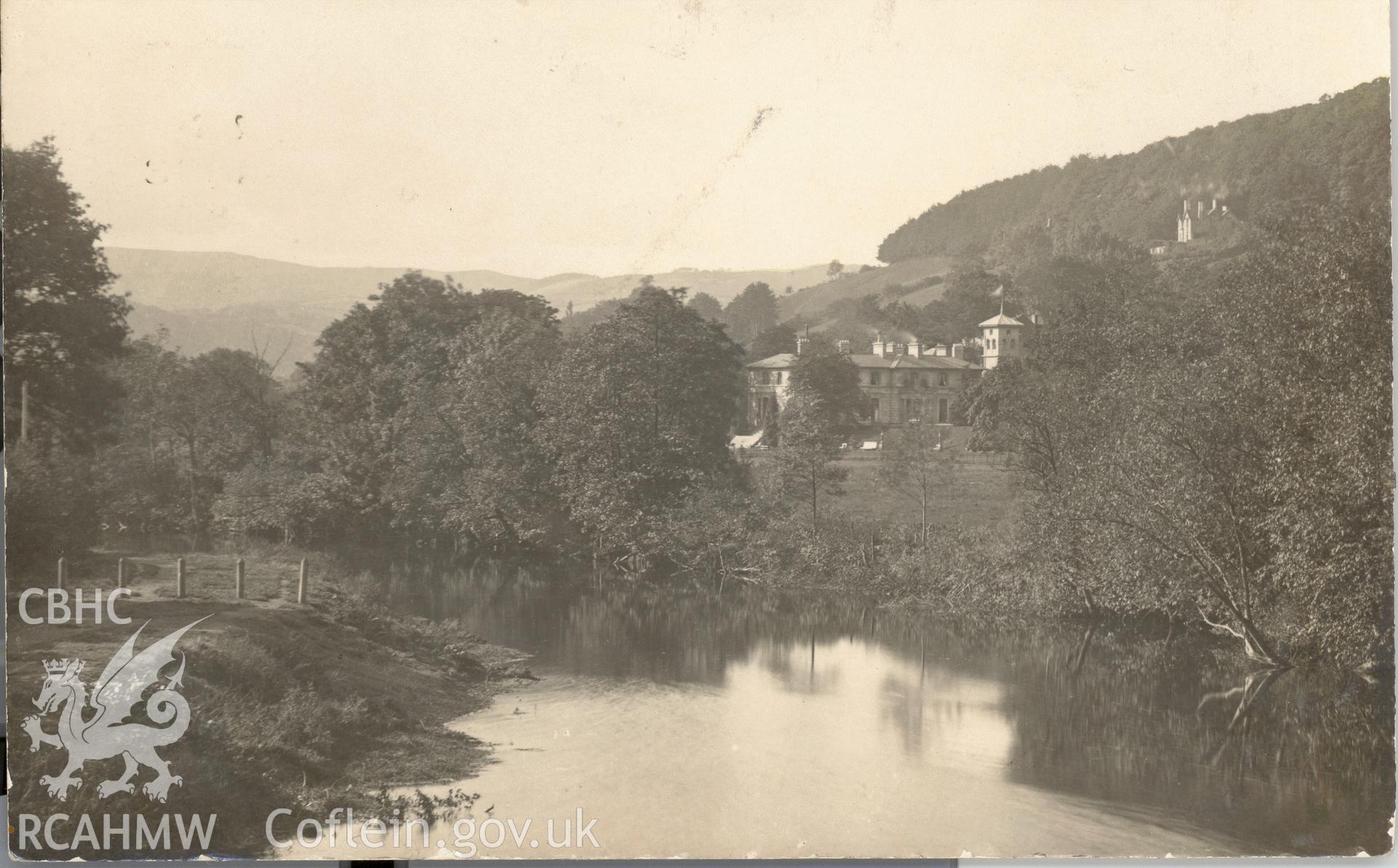 Digitised postcard image of Dolerw, Newtown from the river. Produced by Parks and Gardens Data Services, from an original item in the Peter Davis Collection at Parks and Gardens UK. We hold only web-resolution images of this collection, suitable for viewing on screen and for research purposes only. We do not hold the original images, or publication quality scans.