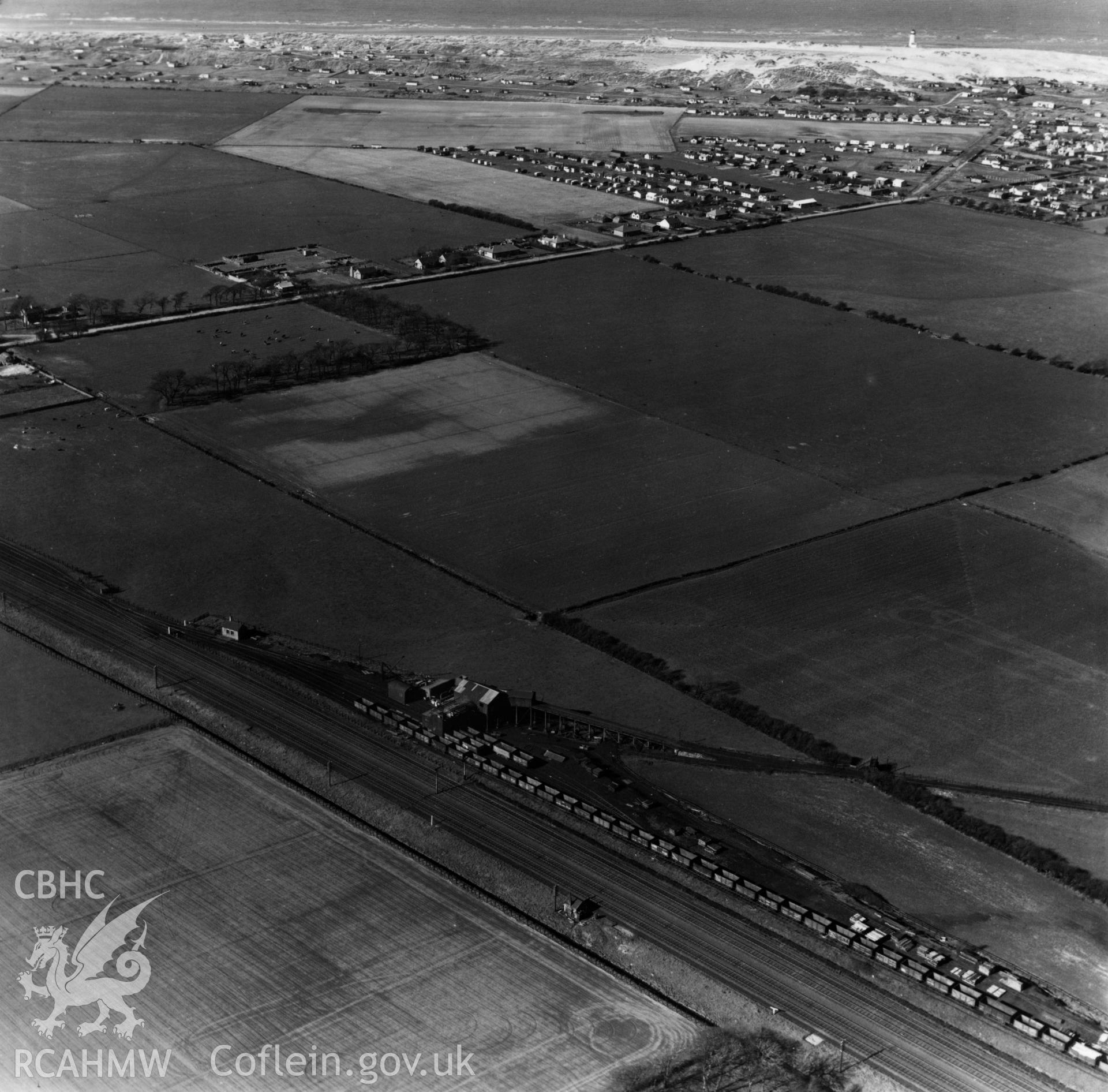 View of Chester & Holyhead railway, Point of Ayr colliery tramway with coal trucks and showing caravans and chalets on the Warren, Point of Ayr. Oblique aerial photograph, 5?" cut roll film.