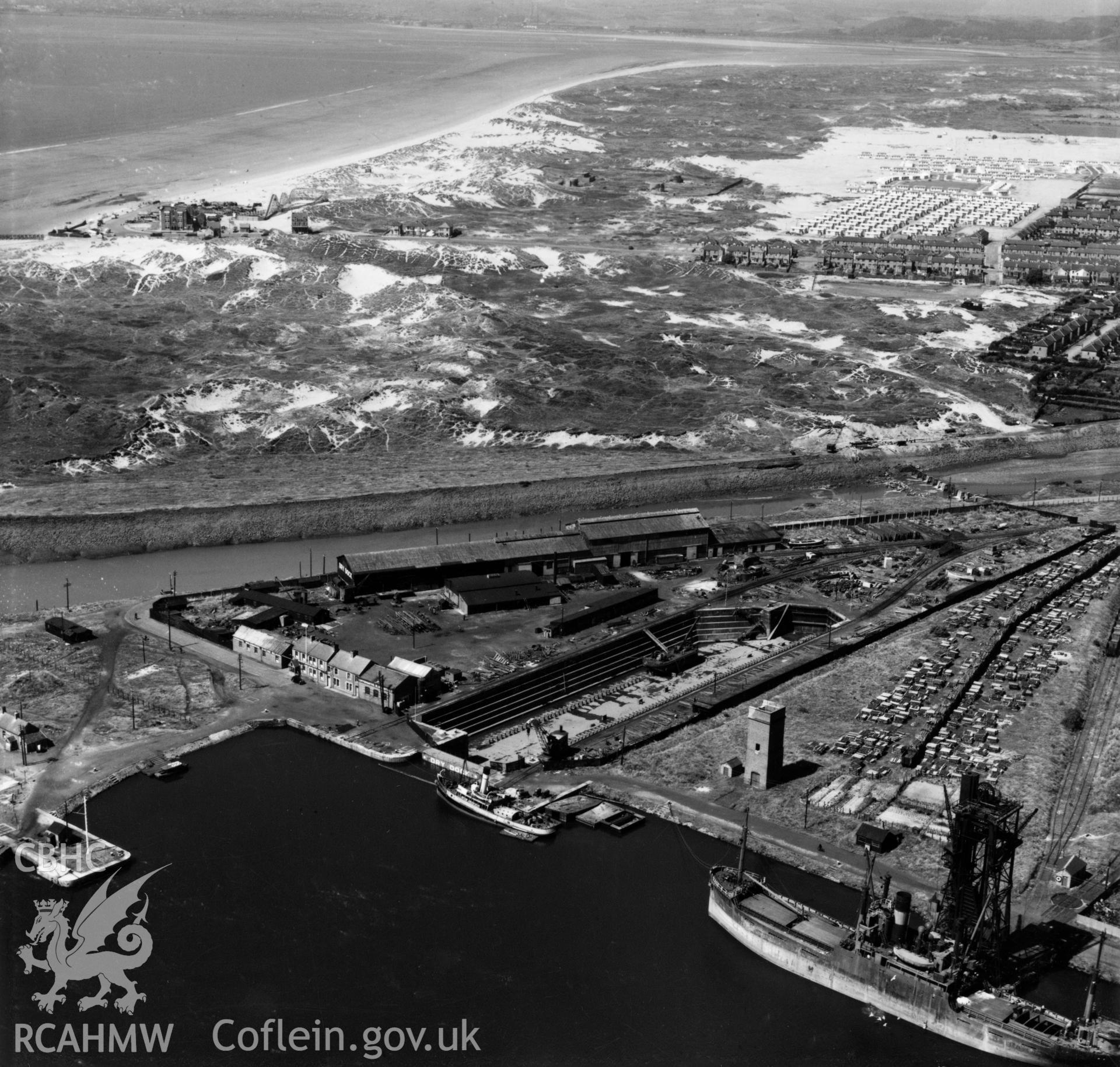 View of docks, Port Talbot, showing derelict Jersey Beach Hotel, funfair and Sandfields estate prefabs at Aberavon in the background. Oblique aerial photograph, 5?" cut roll film.