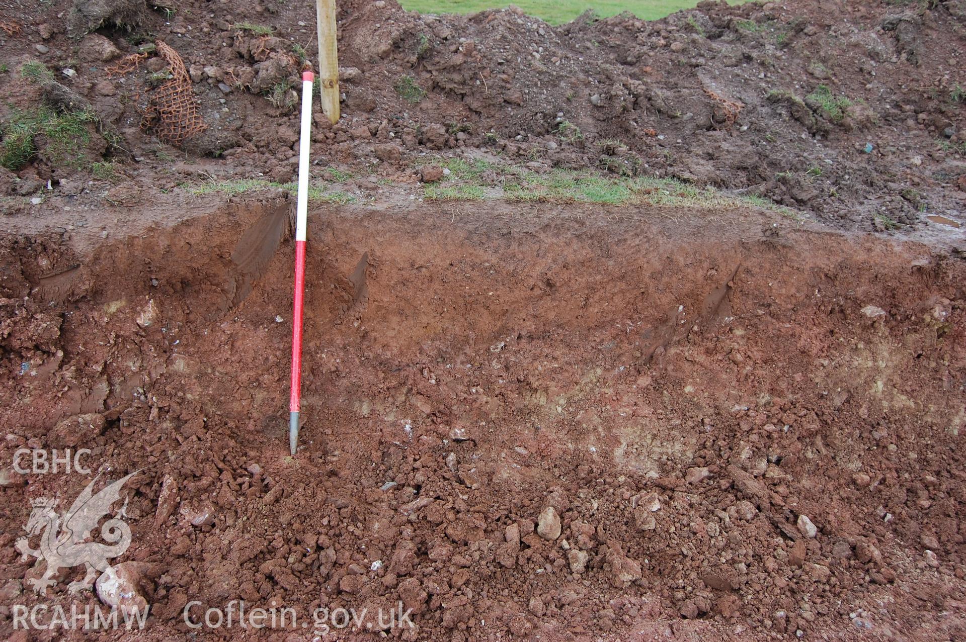 Digital photograph of a section of baulk in the middle of trench, showing hollow filled with 002.