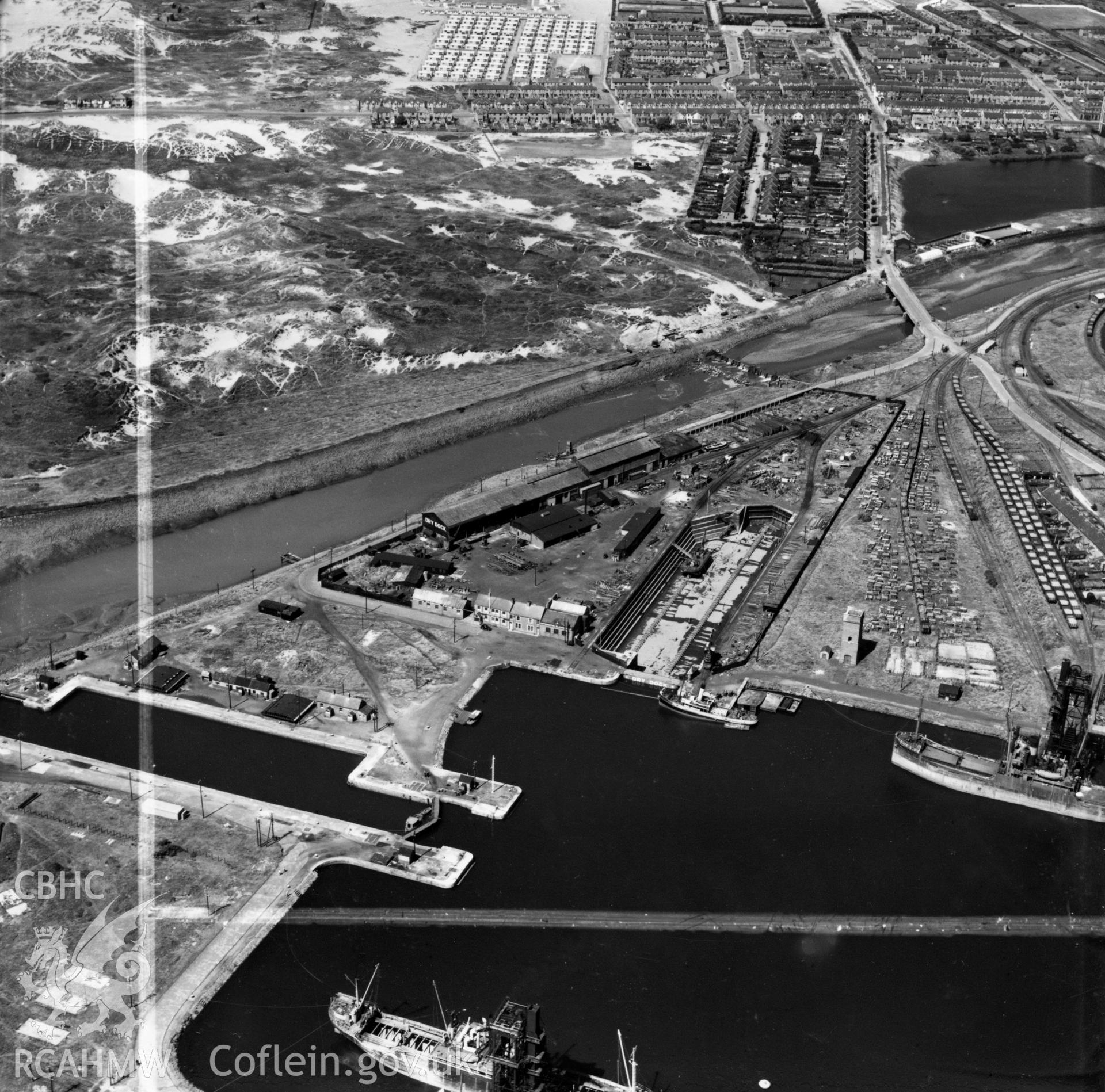 View of dry, new and old docks and entrance channel, Port Talbot, with Sandfields estate in background. Oblique aerial photograph, 5?" cut roll film.