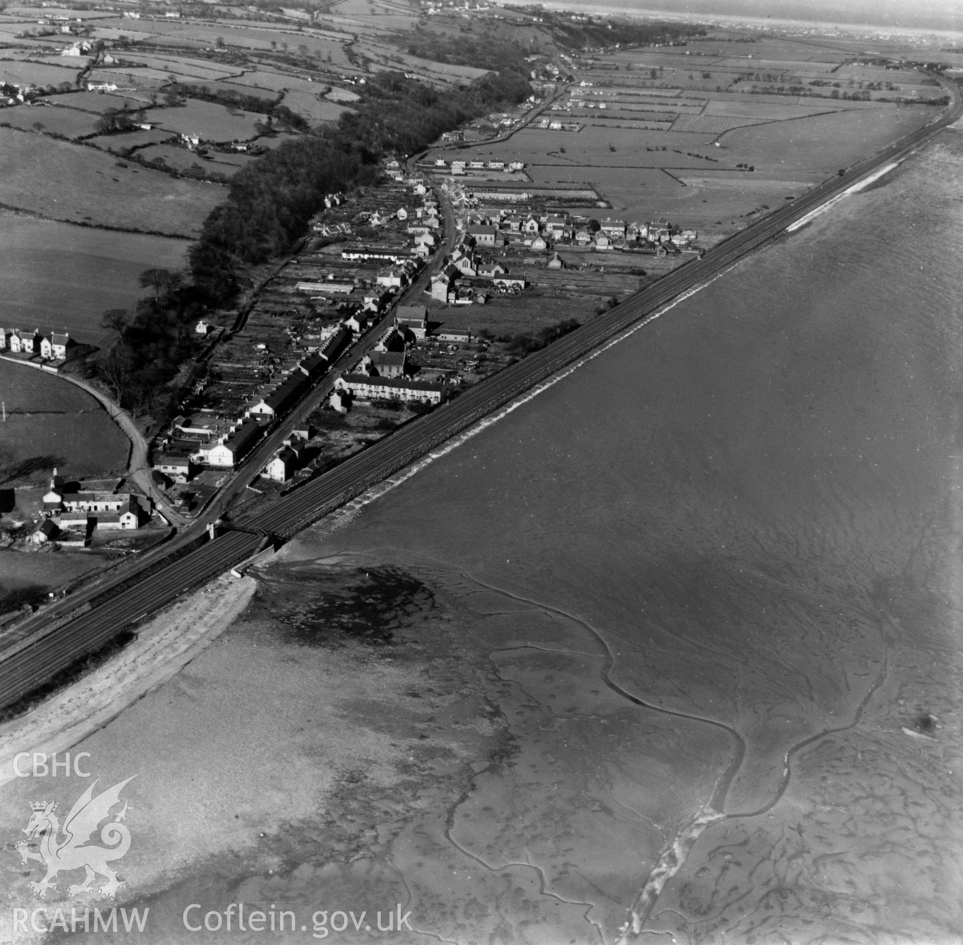 View of Ffynnongroyw and railway looking northwest towards Point of Ayr. Oblique aerial photograph, 5?" cut roll film.