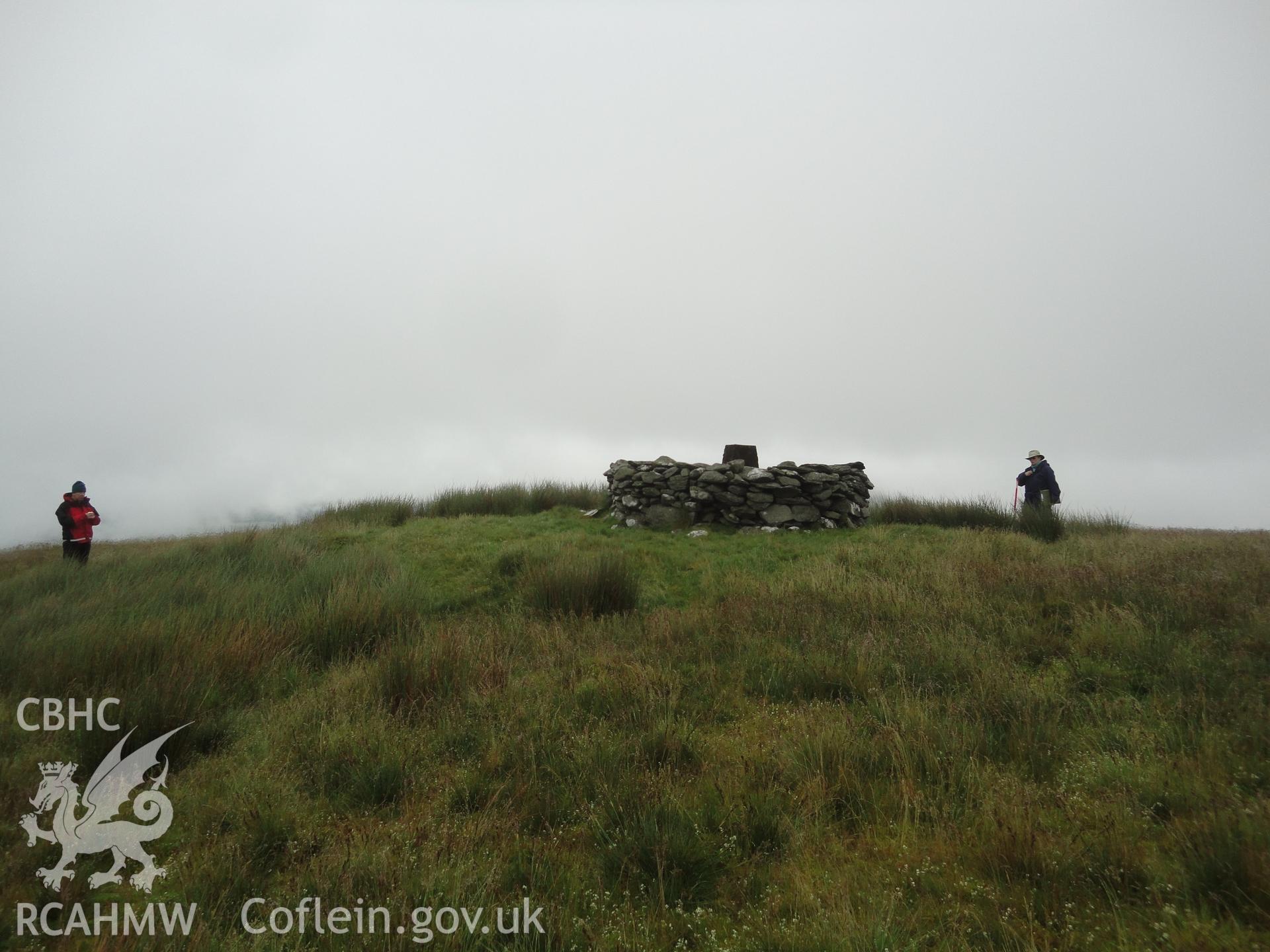 Grass and reed covered cairn with later shelter, NPRN 529013 and triangulation pillar, NPRN 529014 on top, looking northwest.
