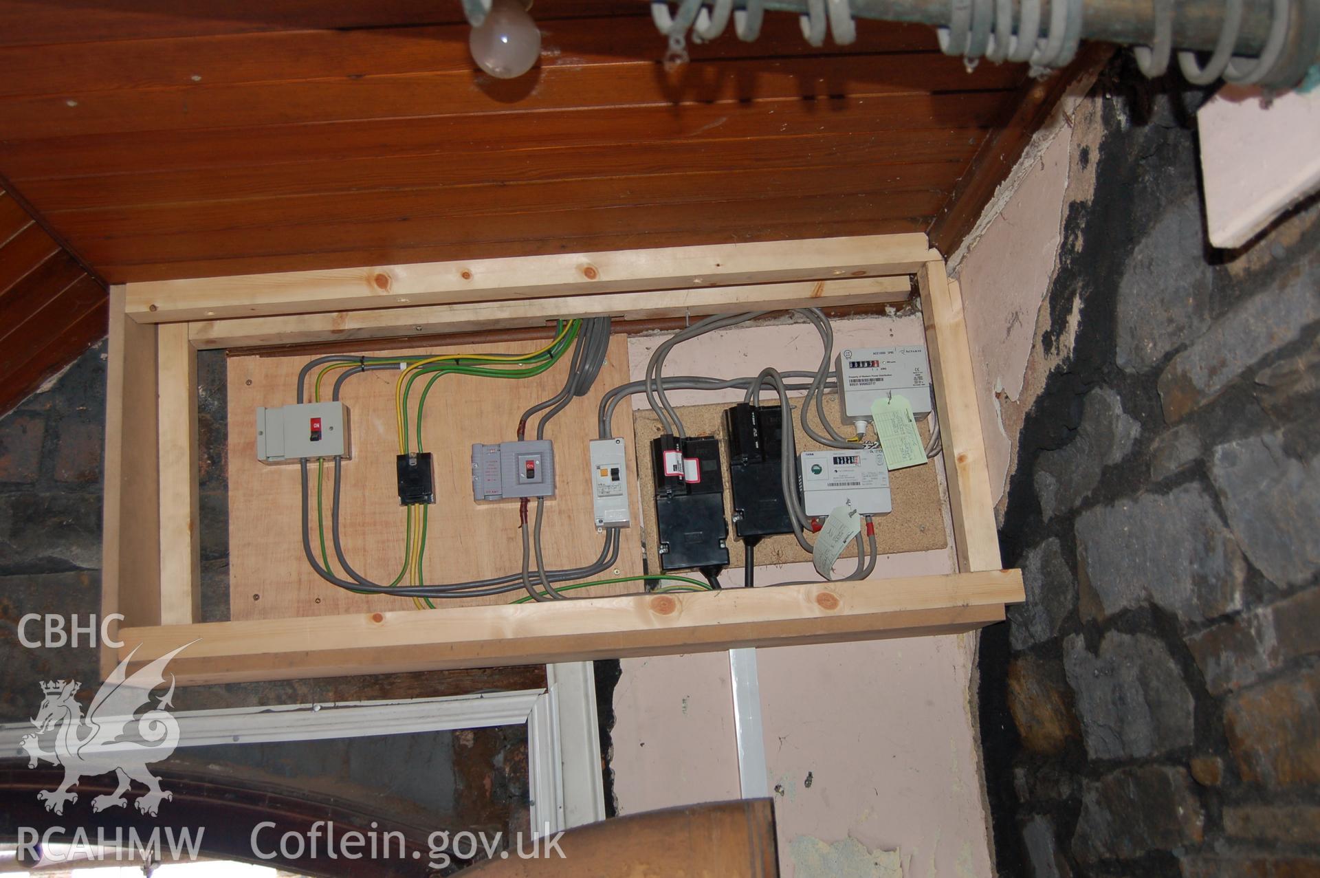 Digital colour photograph showing fuse boxes and electrical wiring above a doorway at the Van Road United Reformed Church.