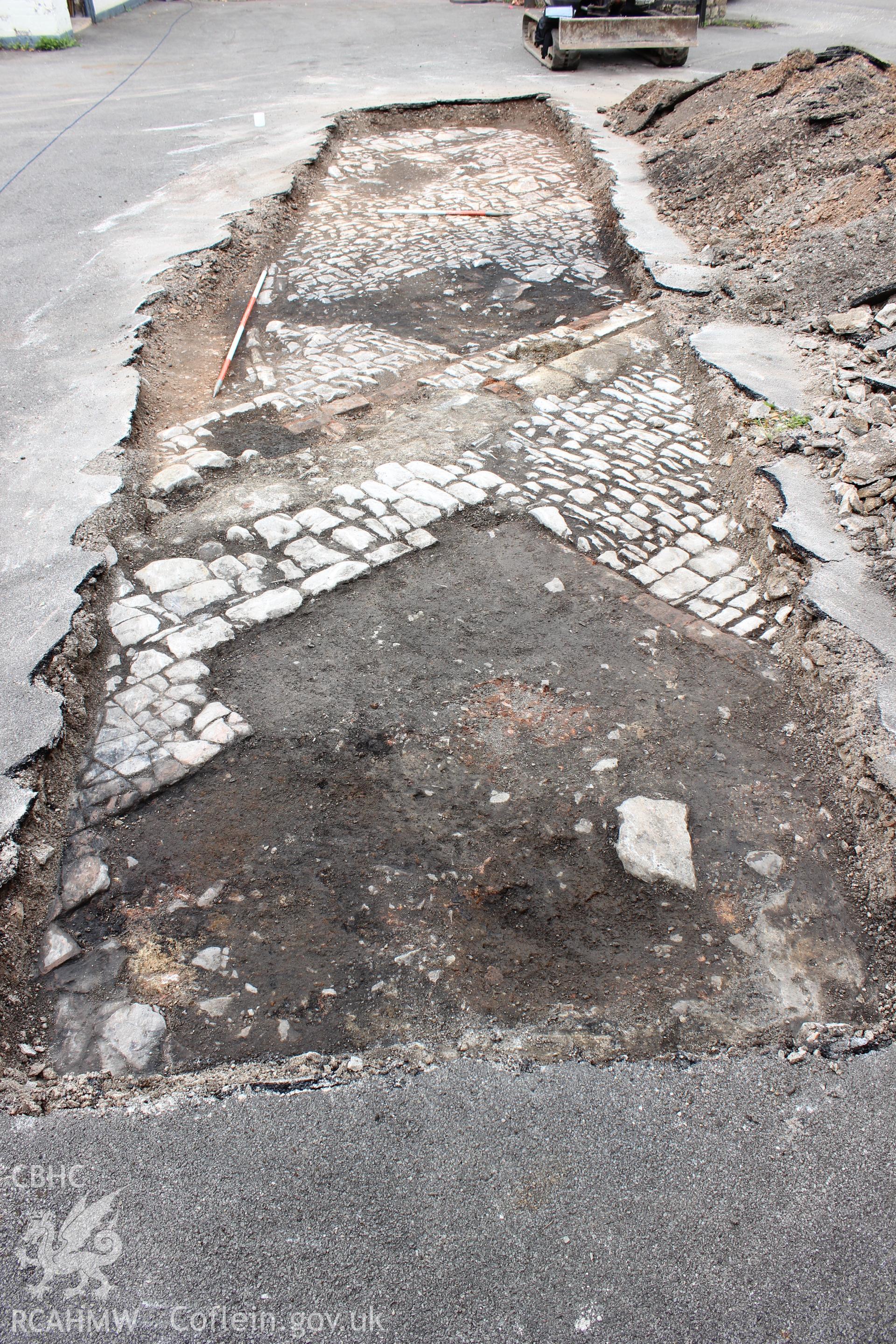 Plan shot of cobbled surfaces and structure, viewed from the east. Photographed as part of an Archaeological Evaluation of The Bridge Inn, Chepstow, carried out by Archaeology Wales, 2015.