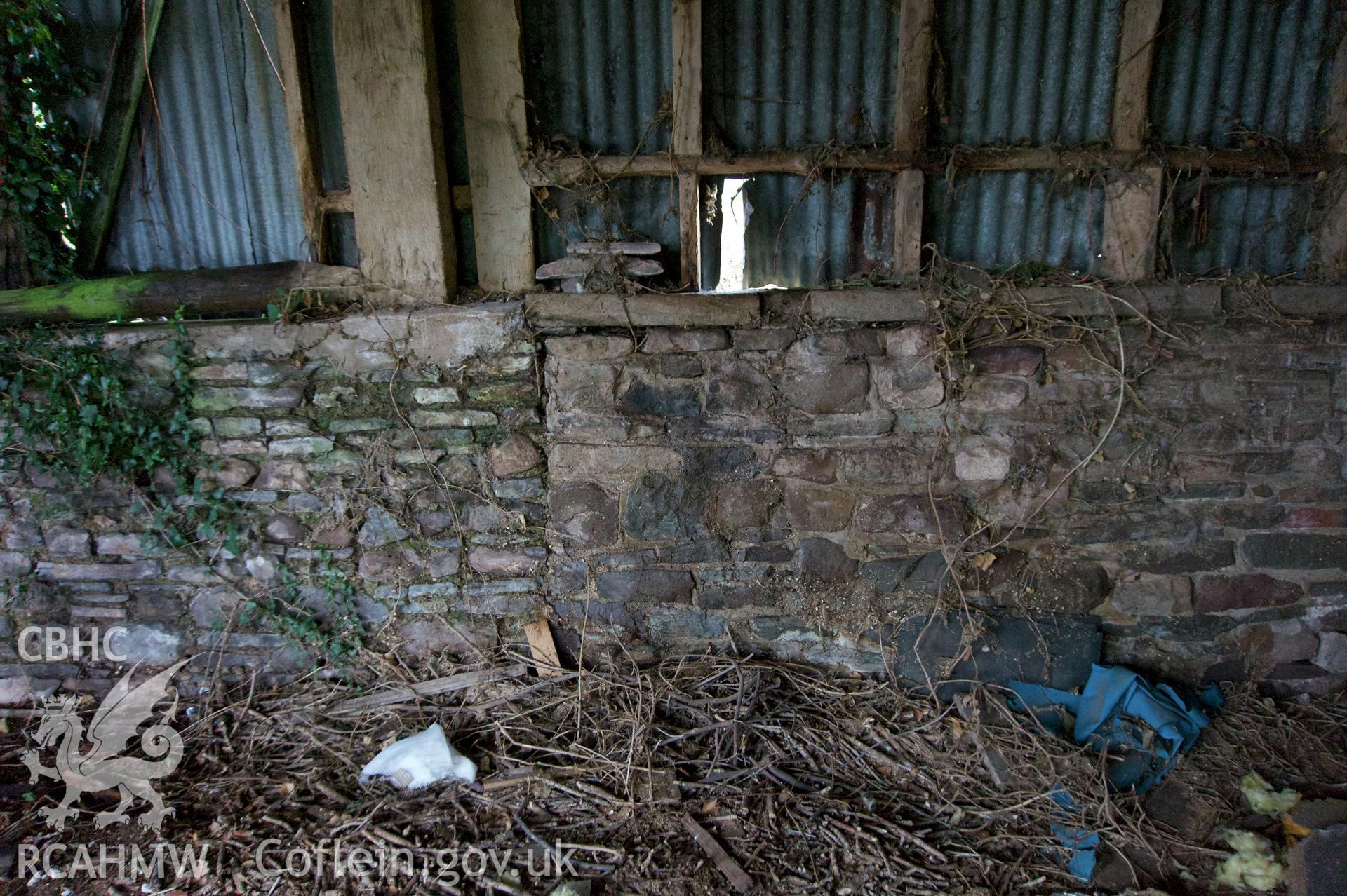 Internal view of west end of south wall showing evidence of historic opening/extension at threshing barn. Photographed for Historic Building Photographic Record of Middle Ton Threshing Barn, Llanvapley, by Dan Courtney of Cog Architects, 2019.