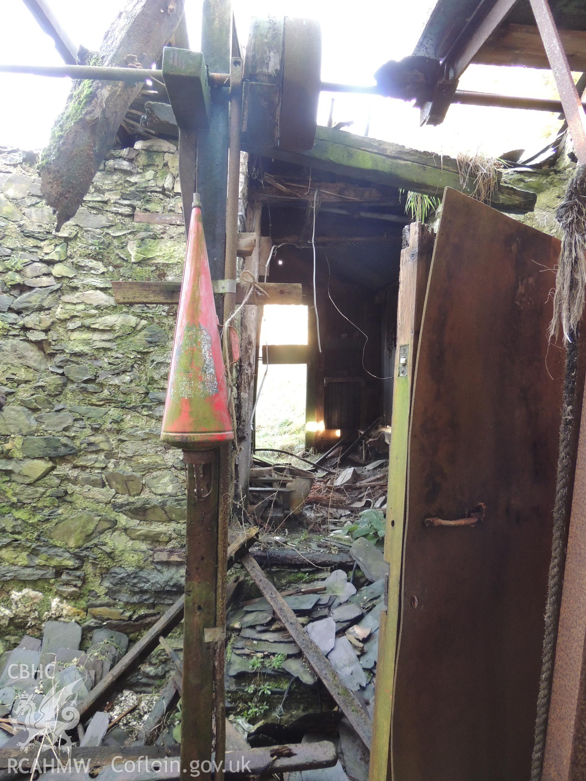 Remains of threshing machine with conical fire extinguisher, looking north. Photographed for archaeological building survey conducted at Bryn Gwylan Threshing Barn, Llangernyw, Conwy, by Archaeology Wales, 2017-2018. Report no. 1640. Project no. 2578.