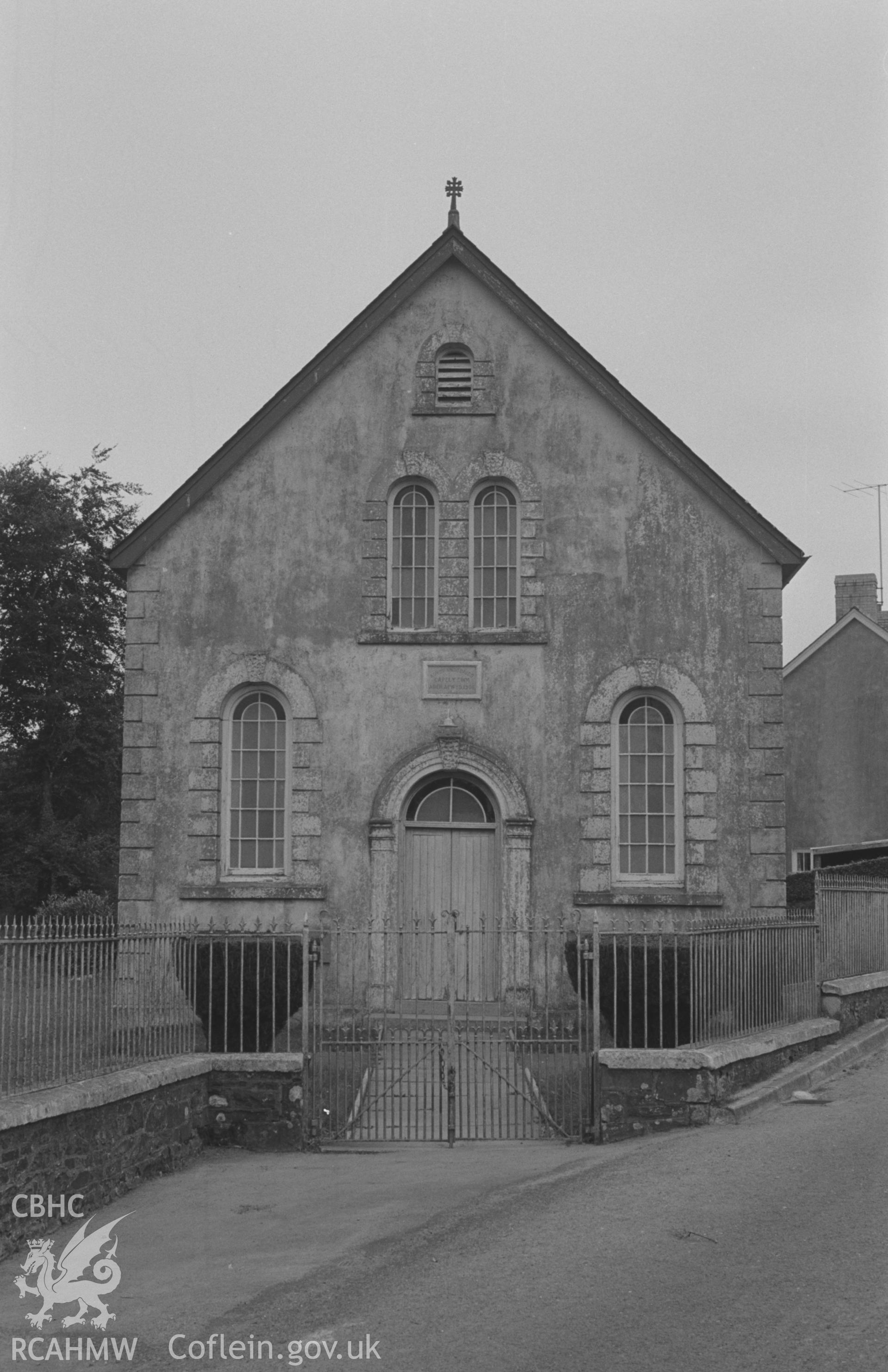 Digital copy of a black and white negative showing Capel-y-Cwm Welsh Unitarian Chapel, on the north side of the main road at Cwmsychbant, Llanwenog. Photographed by Arthur O. Chater in September 1966 looking east from Grid Reference SN 476 462.