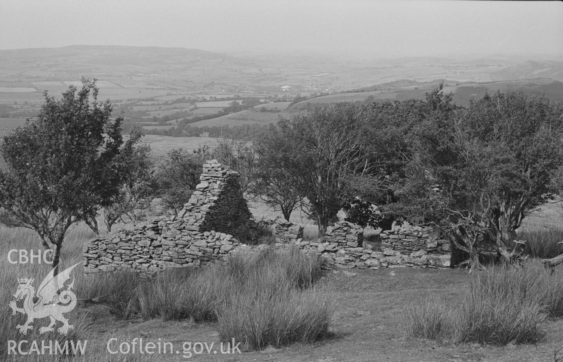 Digital copy of a black and white negative showing Bryn Du, the uppermost ruin on the slope of Bryngwyn Bach, 300m south south west of Ty-Newydd; 1175 ft.  Part of the Bryneithinog squatter settlement. Pontrhydfendigaid in the background. Photographed by Arthur O. Chater in August 1967. (Looking north from Grid Reference SN 7321 6284).