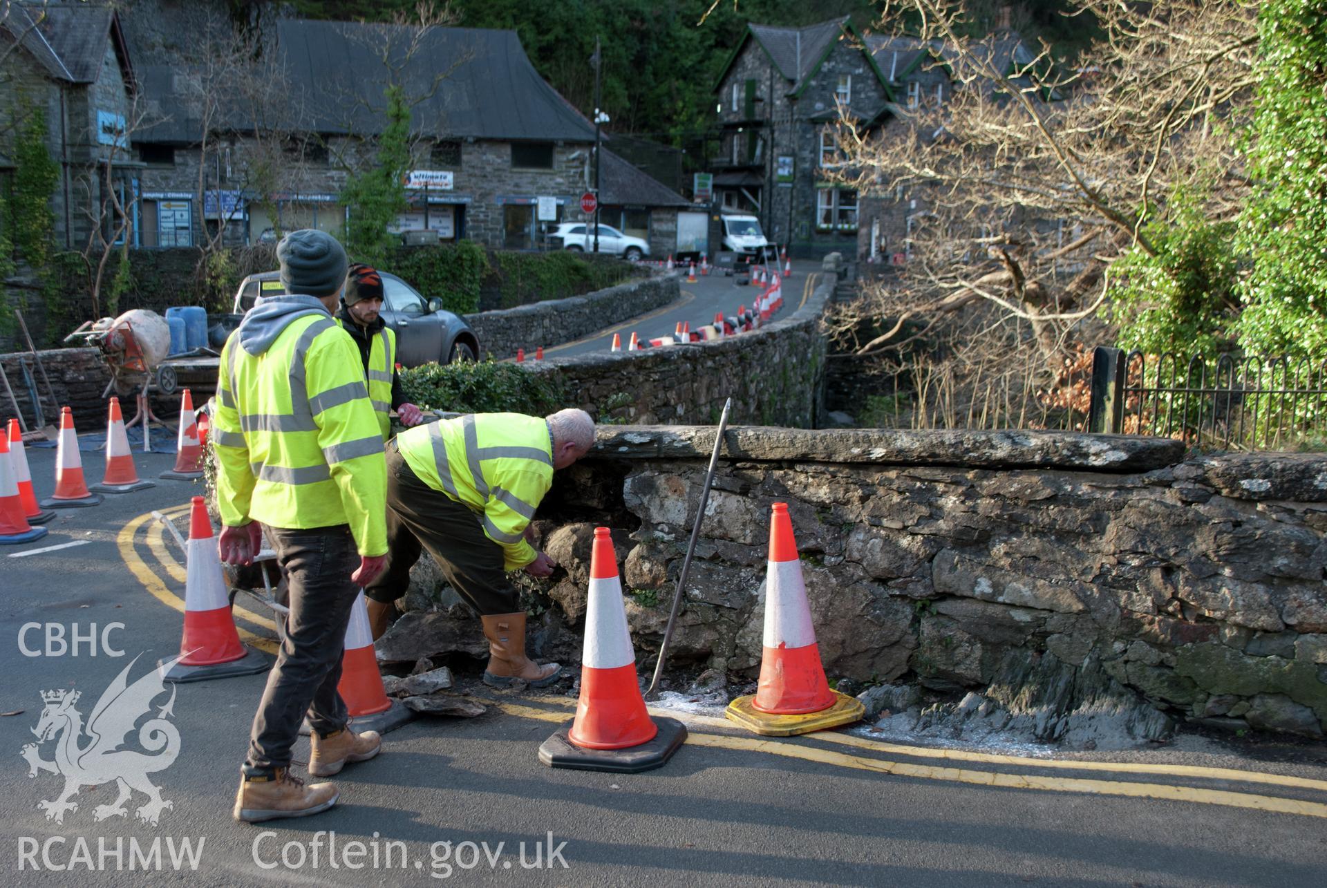 General shot from the north west of repair work to stones below large coping stone at northwestern end of parapet. Digital photograph taken for Archaeological Watching Brief at Pont y Pair, Betws y Coed, 2019. Gwynedd Archaeological Trust Project G2587.