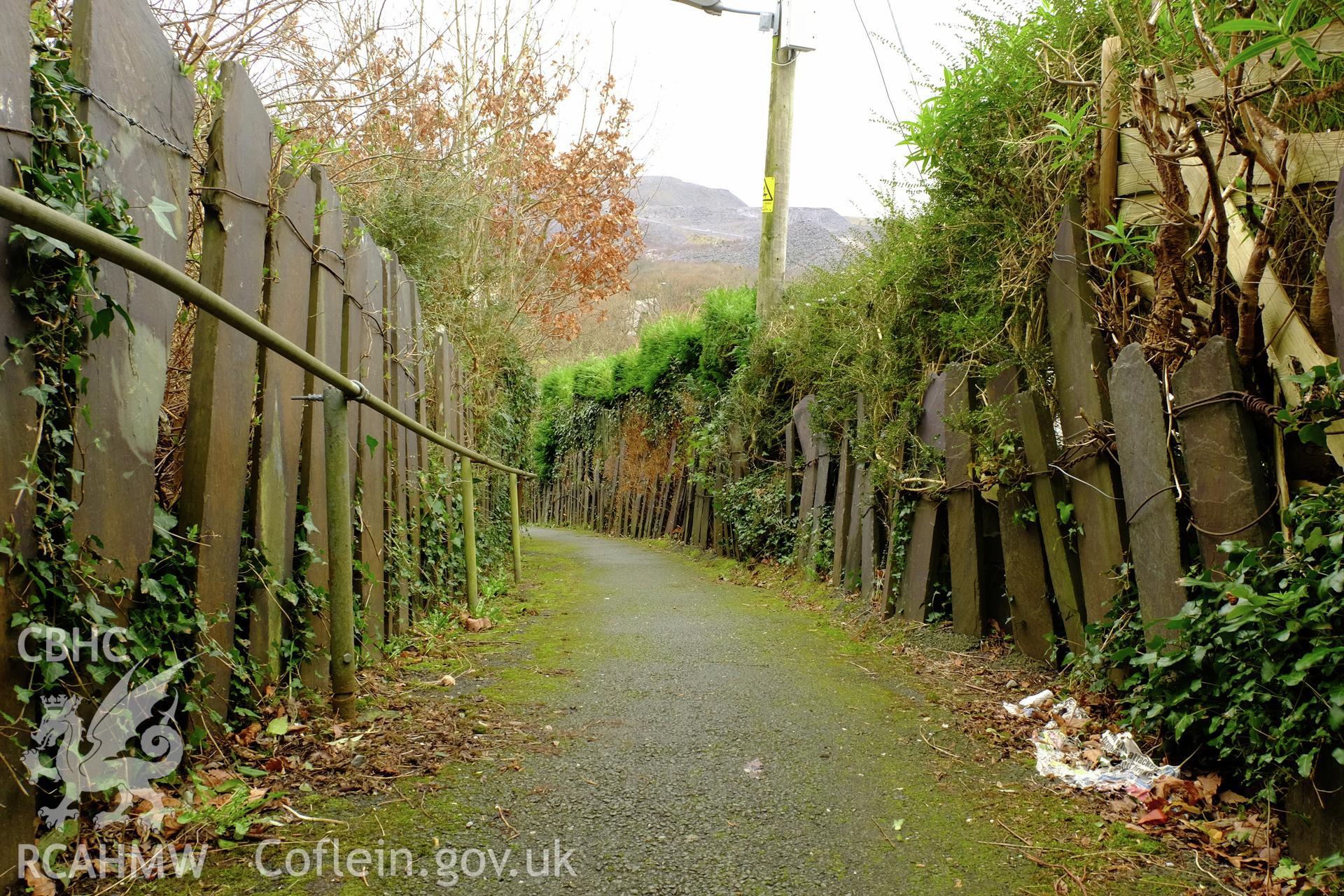 Colour photograph showing view looking south west, showing slate fences on footpath below Well Street, Gerlan, Bethesda, produced by Richard Hayman 16th February 2017