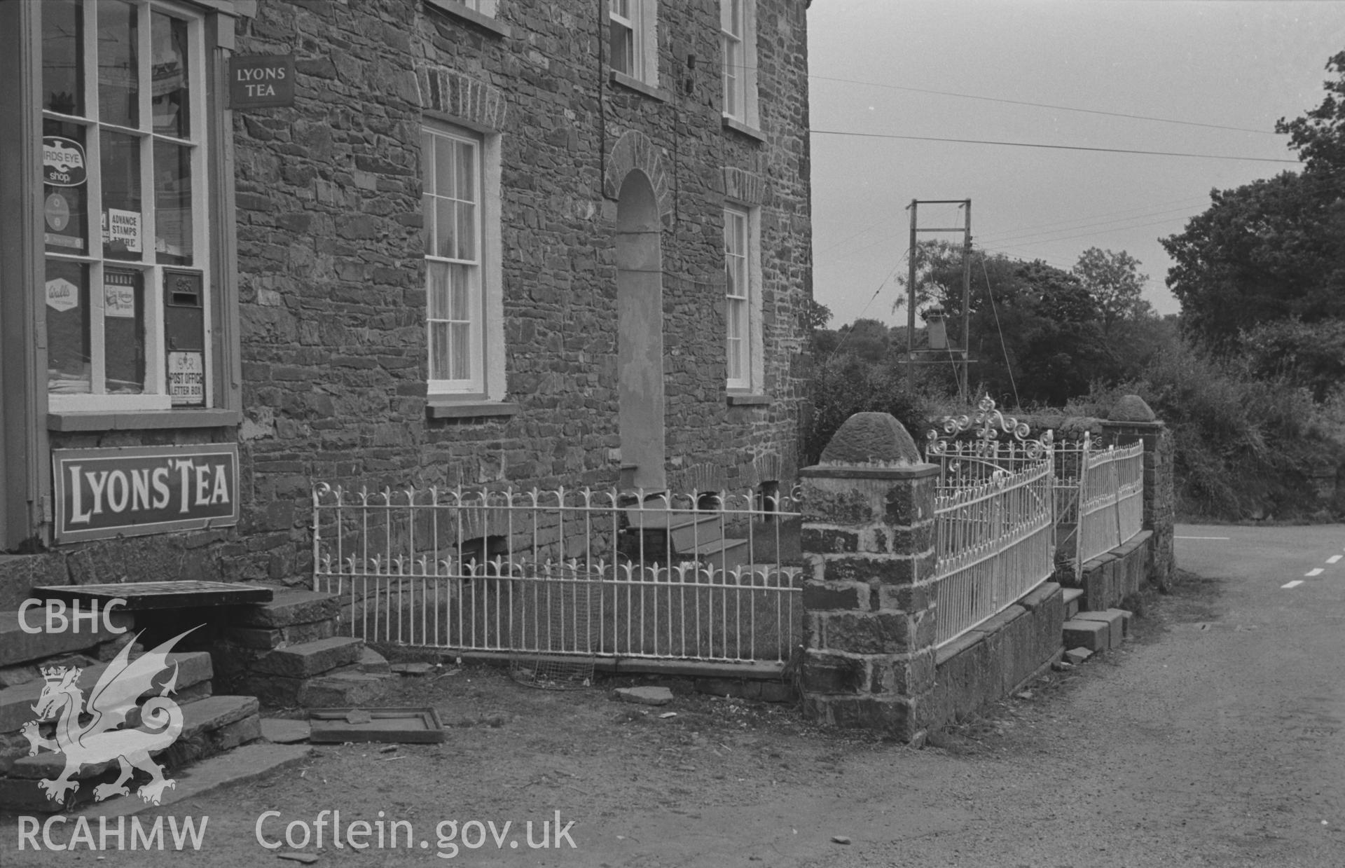 Digital copy of a black and white negative showing iron railings at the front of house in the north angle of the crossroads at Oakford, Aberaeron. Photographed by Arthur O. Chater on 5th September 1966, looking south from Grid Reference SN 452 580.