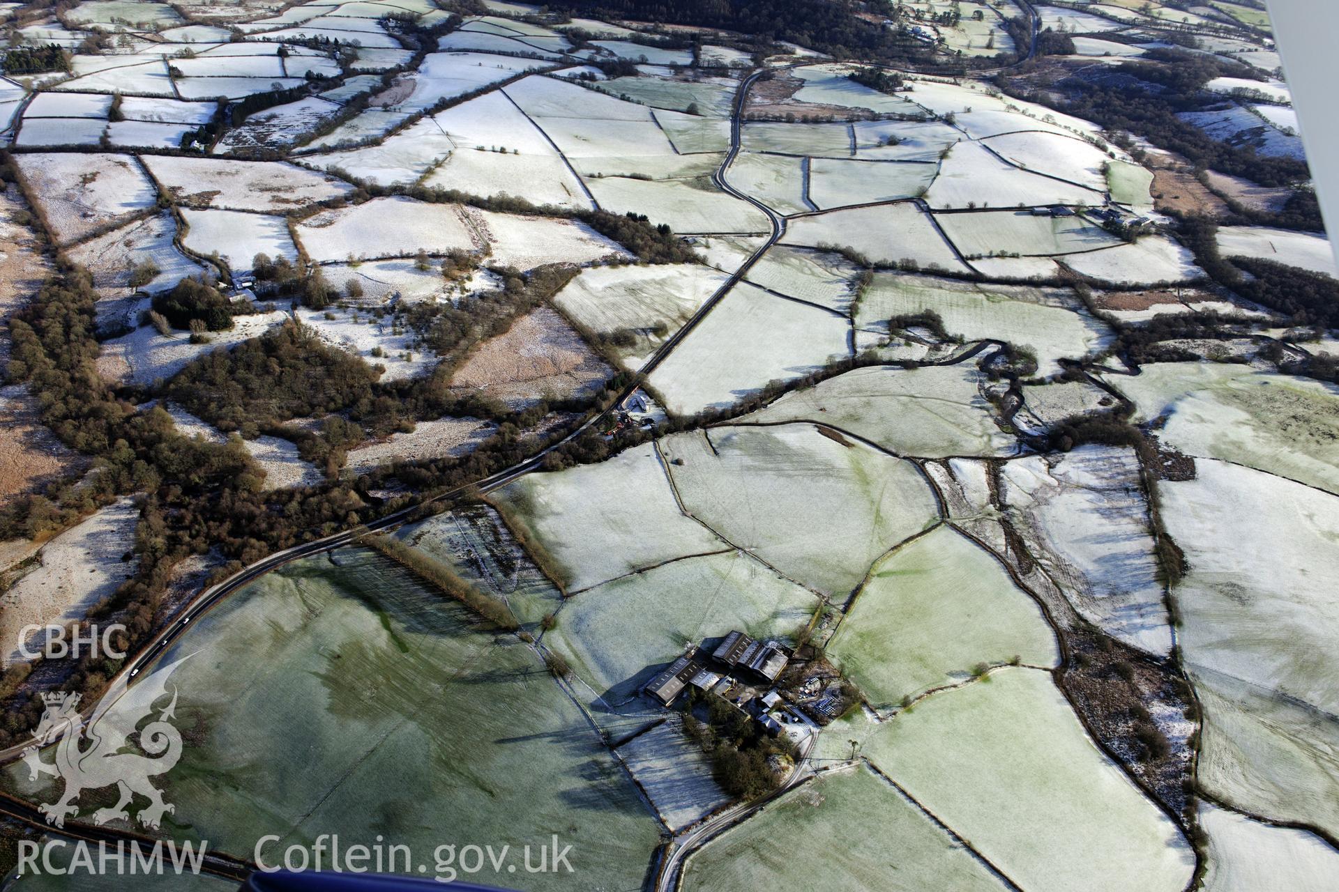 Twdin or Caerau Motte, Caerau Roman fort and military settlement, and the Roman road from Carmarthen to Castell Collen (RR623). Oblique aerial photograph taken during the RCAHMW?s programme of archaeological aerial reconnaissance by Toby Driver 15/01/2013.