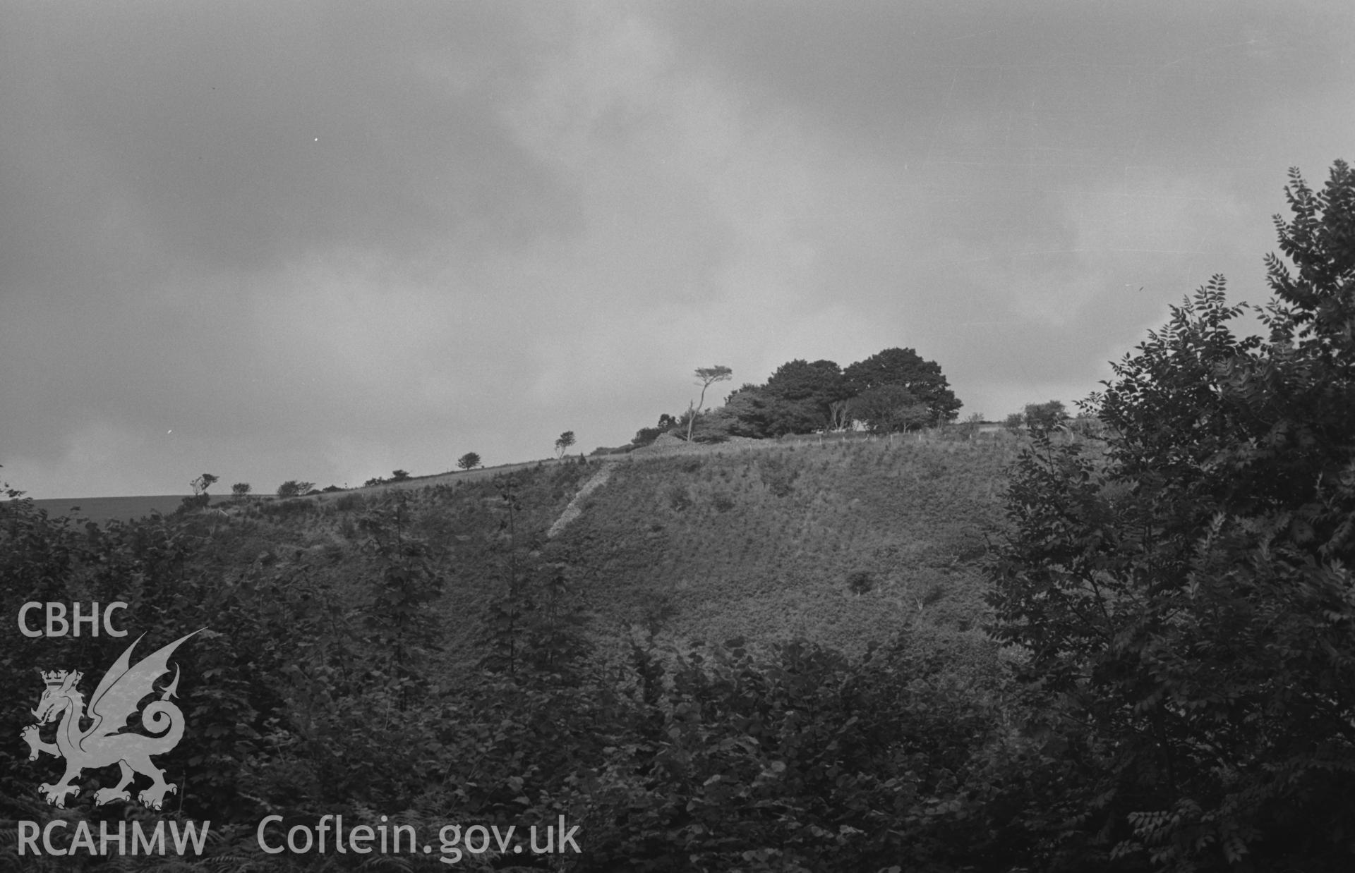 Digital copy of black & white negative showing Garn Wen iron-age camp, 2.3km east of Ffostrasol, from Pen-y-Graig farm; S.W. end of rampart, showing as drystone mound on skyline in centre of picture; wall running down slope from this is presumably a modern wall built from the stores of the ramparts. Photograph by Arthur Chater, Aug 1967. (Looking north north east from Grid Reference SN 395 468).