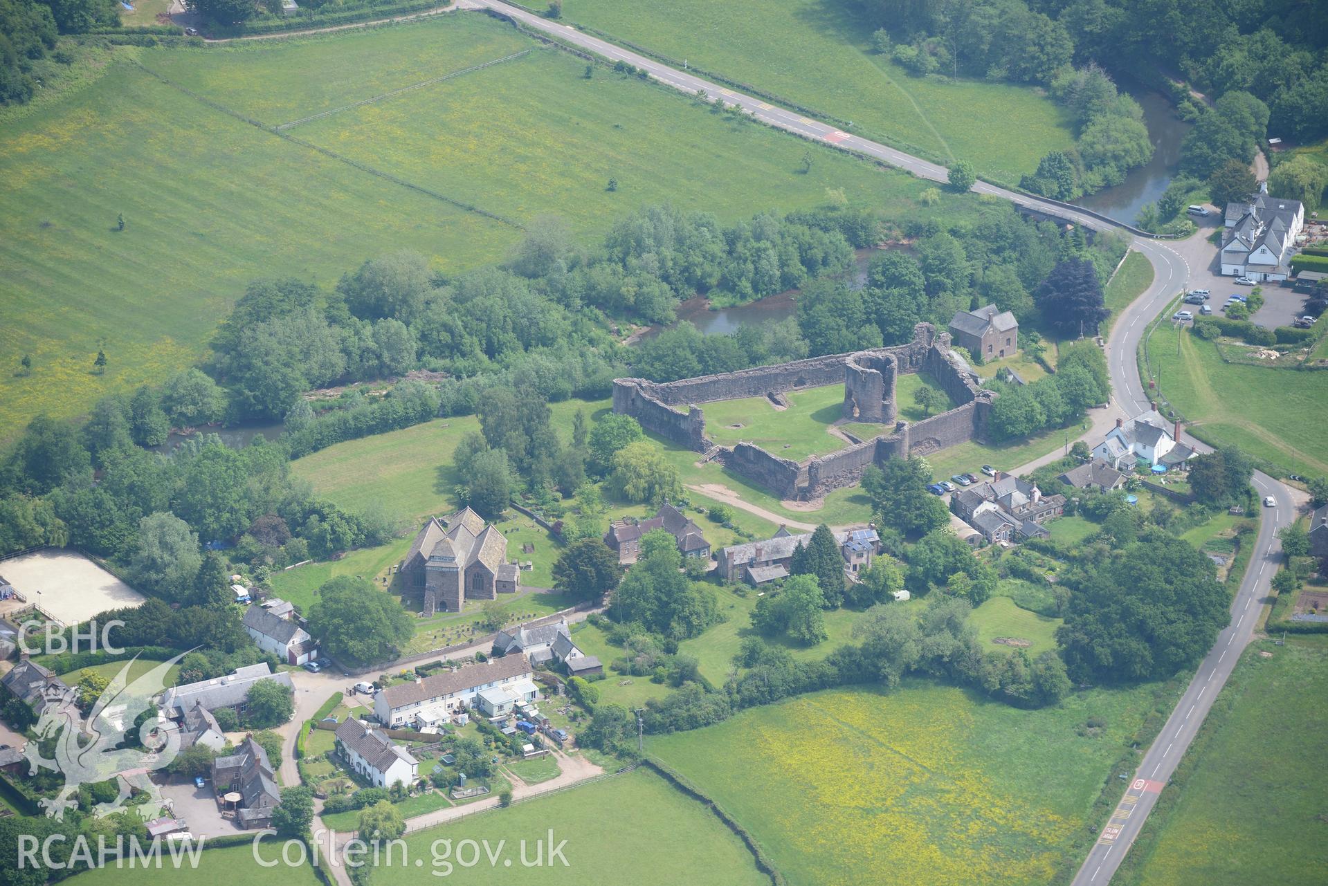 Skenfrith town including views of the castle; St. Bridget's Church; corn mill and the Old Shop. Oblique aerial photograph taken during the Royal Commission's programme of archaeological aerial reconnaissance by Toby Driver on 11th July 2015.
