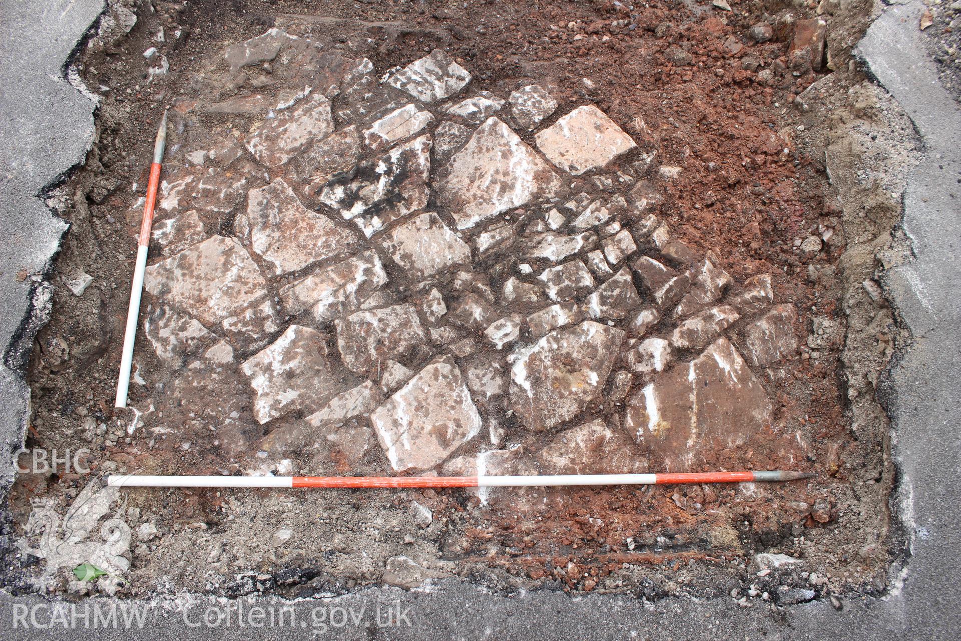 Detail shot of cobbled underlying surface, viewed from the east. Photographed as part of an Archaeological Evaluation of The Bridge Inn, Chepstow, carried out by Archaeology Wales, 2015.