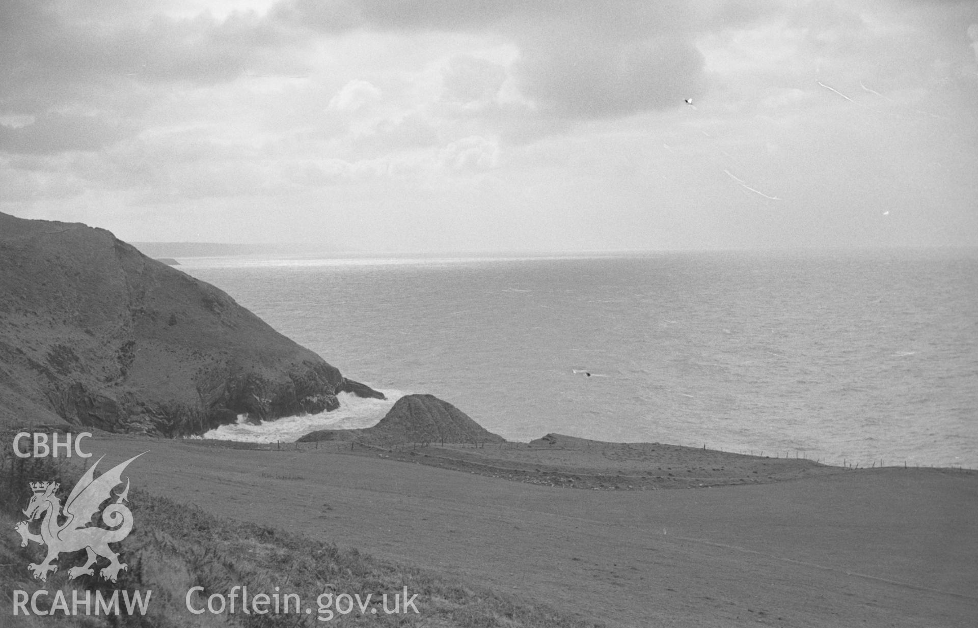 Digital copy of a black and white negative showing view looking across outer ramparts to the inner ramparts of Castell Bach promontory fort. Photographed by Arthur O. Chater in April 1966 looking west south west from Grid Reference SN 362 582.