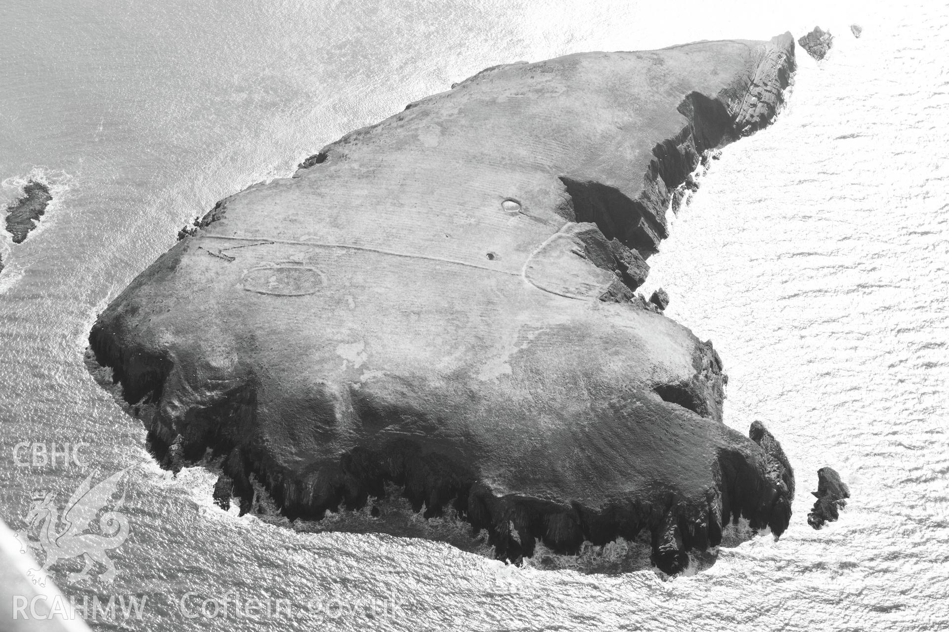 Cardigan Island, viewed from the north west. Features visible include cultivation features; landing point; linear bank crossing; ponds; possible cairn; possible round house; promontory enclosure and settlement enclosure. Oblique aerial photograph taken during the Royal Commission's programme of archaeological aerial reconnaissance by Toby Driver on 2nd April 2013.