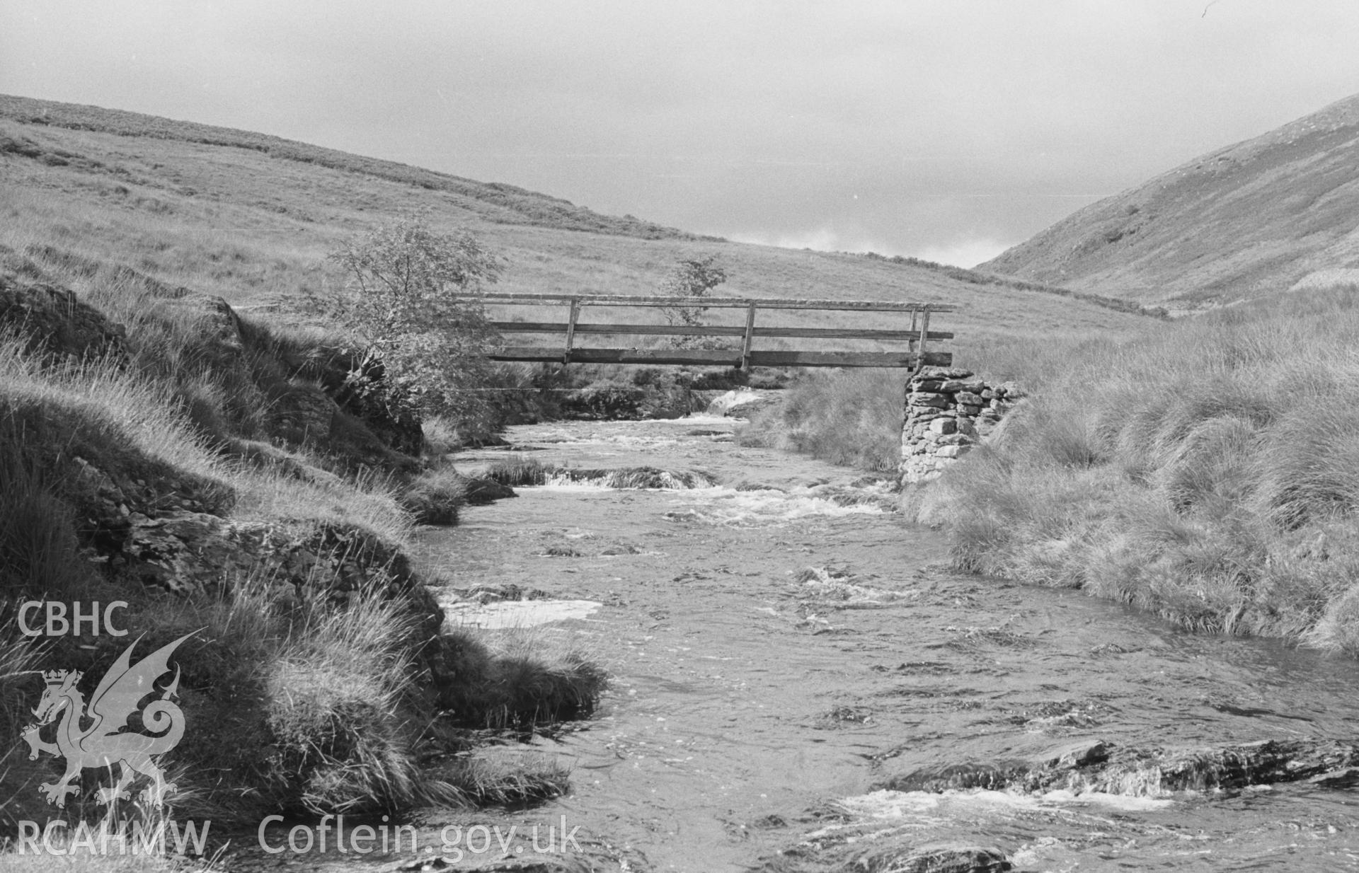 Digital copy of black & white negative showing wooden footbridge with dry-stone abutments across the Camddwr, 100m above Capel Soar-y-Mynydd, Llanddewi Brefi. Photographed in September 1963 by Arthur O. Chater from Grid Ref SN78485337, looking north west.