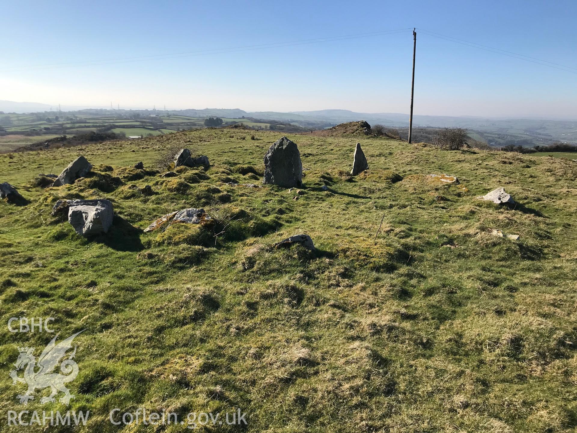 Digital colour photograph of a round cairn or kerb circle on Mynydd Llangyndeyrn, east of Crwbin, taken by Paul R. Davis on 26th February 2019.