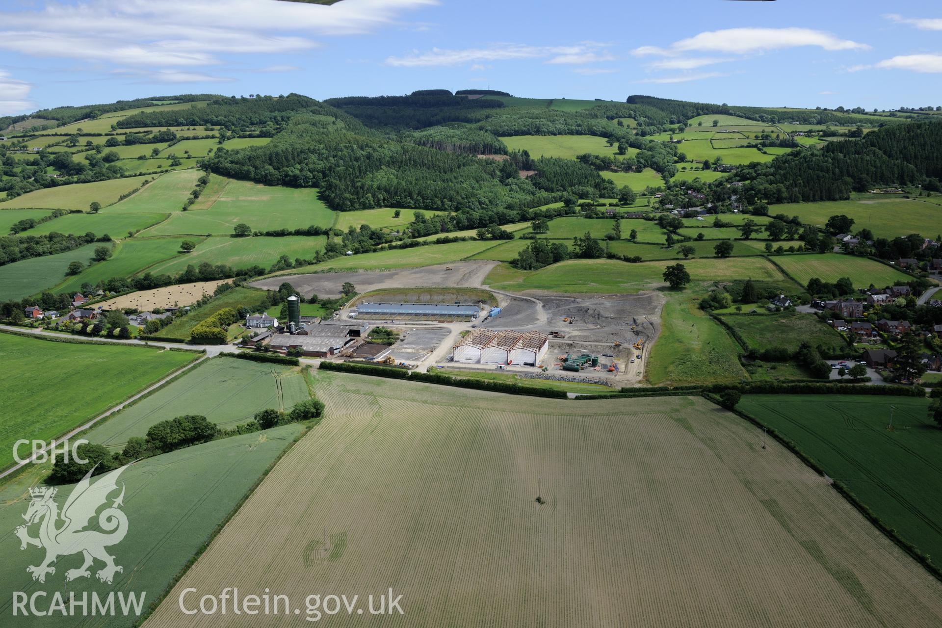 Lower Leighton farmhouse and the new 'super dairy' under construction at Lower Leighton Farm, Leighton, Welshpool. Oblique aerial photograph taken during the Royal Commission's programme of archaeological aerial reconnaissance by Toby Driver on 30th June 2015.