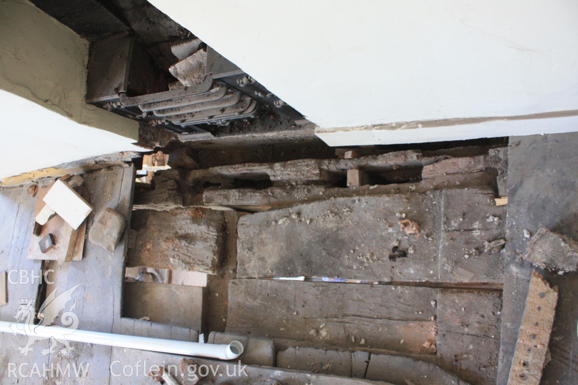 Colour photograph of girt beam showing mortices for studs (seen running across ground floor chimney breast) at Porth-y-Dwr, 67 Clwyd Street, Ruthin. Photographed during survey conducted by Geoff Ward on 10th June 2013.