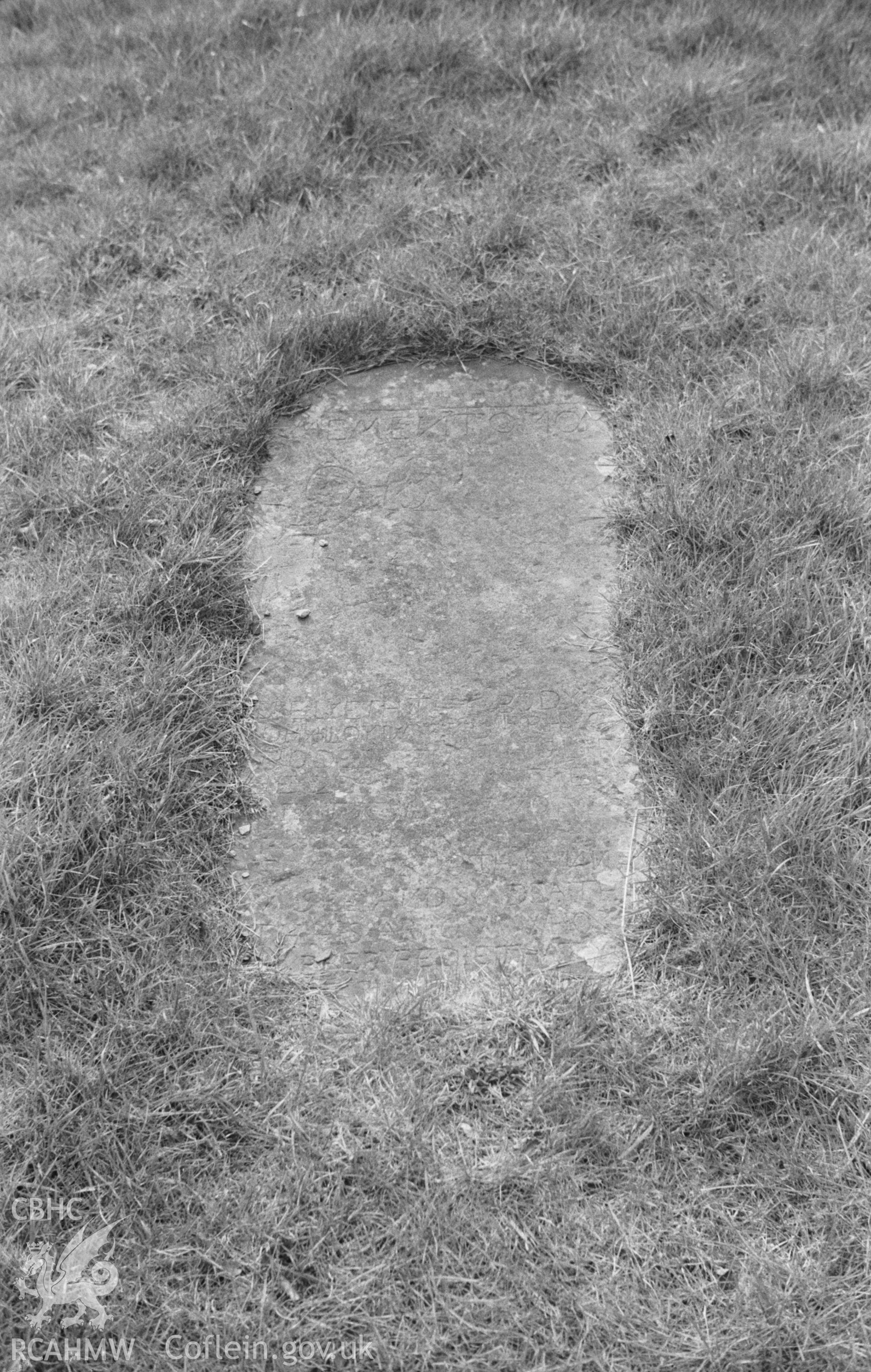 Digital copy of a black and white negative showing gravestone on the south side of St. Padarns church, Llanbadarn Odyn. Photographed in April 1964 by Arthur O. Chater from Grid Reference SN 6344 6047.
