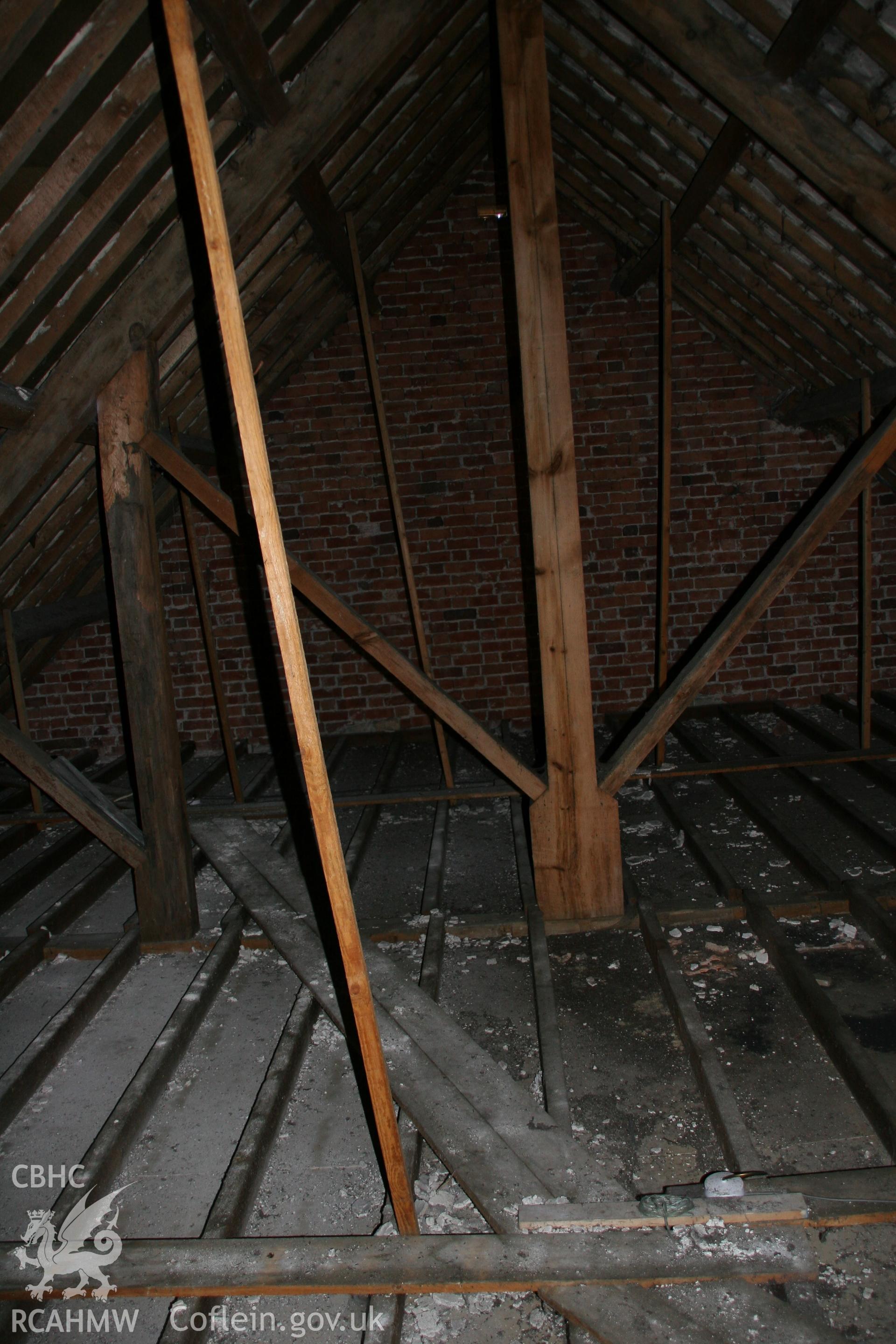 Photograph showing interior view of wooden beams, floor boards & brick wall in loft of former Llawrybettws Welsh Calvinistic Methodist chapel, Glanyrafon, Corwen. Taken by Tim Allen on 27/02/2019 to meet a condition attached to planning application.